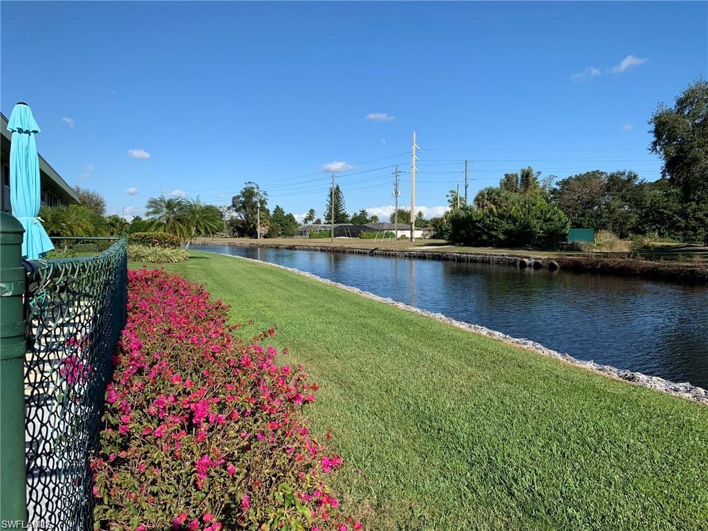 Talk about a GREAT LOCATION! This lovely first floor condo is close to everything with view of the wide Lely Canal flowing along the Hibiscus Golf Course. The Hammock Cove shopping center is “almost walkable” for groceries, banks, restaurants, and medical needs. Just a short drive to the sandy beaches and Naples 5th Ave S.  This 2 BR/2 BA residence is super clean.  The split BR plan offers you and your guests privacy. Parking is available right in front of your building. A/C and H/W Heater have been recently replaced as well as the brand new Samsung washer and dryer. The primary walk-in bedroom closet has had a luxury California Closet System installed with a lovely white barn style door for privacy in the primary bath and closet. The sliding glass doors to the lanai fill this great condo with light and allow for the best of indoor-outdoor entertaining as well as the open plan from the kitchen to the dining room and great room.  Enjoy sunrise views over the canal and golf course. Lovely heated community pool to relax in as well as grills in the courtyard area.  Hurry and make this wonderful home yours. This friendly community is awaiting you and yours.
