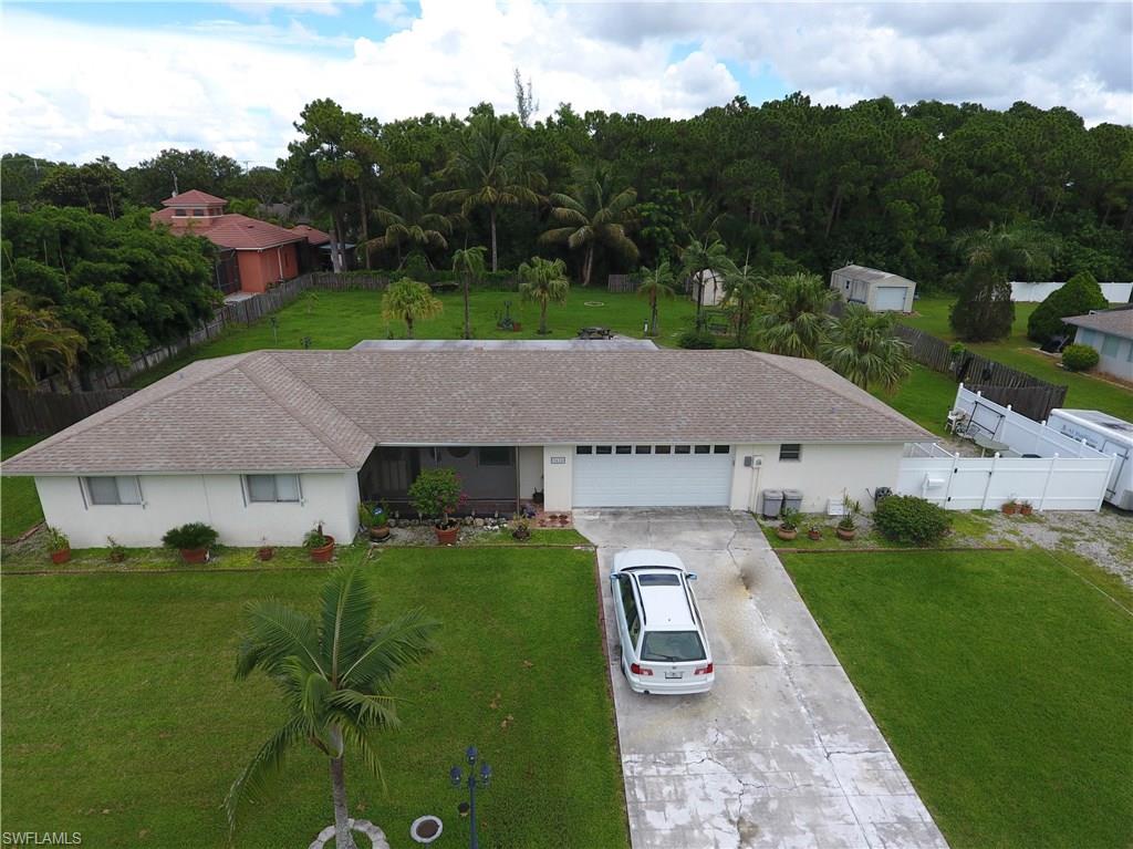 This is a 3/2 on one side of the 2 car garage, and an efficiency with kithchen and bath on the other.  The efficiency has its own parking and own entrance!  One of the largest lots available, just 2 miles to the beach.  This home has electric in the shed, an RV hookup in the back yard with electric and sewage bail  newer A/C  Granite in the kitchen with newer cabinets.  Full hurricane shutters, and on the fire station grid, so power in just 2 days after the largest storm in the world and Bonita Springs took the direct hit!!  Not even a tree down on this property!!  Not many lots over 1/2 acre this close to the beach out there at this price!  Close to shopping, and only a 20 minute ride to the airport.  Come see and make an offer