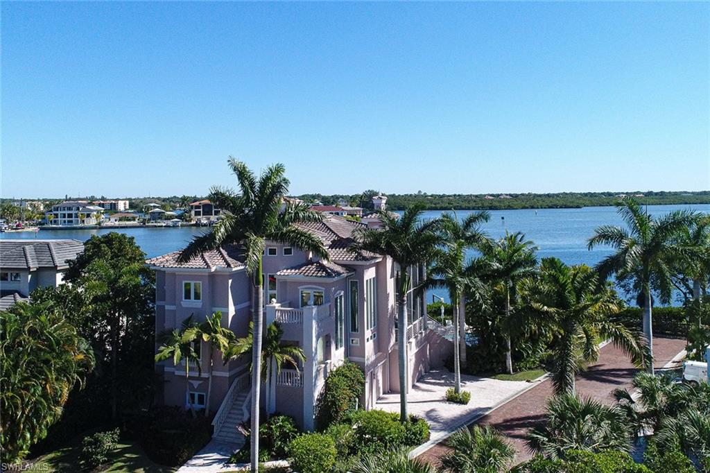 This beautiful three story Barefoot Beach home sits on one of the best, if not the best wide bay lot in double gated Southport on the Bay. Walk to the beach via dedicated beach access, boat to the Gulf of Mexico in minutes with no bridges via jet skis or boat from your double dock with lifts, enjoy the newer state of the art swimming pool with large beach shelf & spa overlooking the bay in a private setting, & you can purchase a Club at Barefoot Beach membership at closing (currently a 5 year waitlist) offering fine & casual dining inc beverage & food service at the pool & beach, a full social calendar of events & tennis courts. This coastal contemporary home offers an open floor plan w/volume ceilings, large multiple living areas and outdoor lanais and decks, wide bay views from most rooms including from kitchen over looking family room and lanai, large master suite with large picture windows to the floor over looking the bay plus large deck off master, 5 bedrooms, 5 1/2 baths, office, theater, fitness room and rec room with pool table, 3 car garage concrete construction & impact glass A well maintained home w/recent exterior paint & turnkey furnishings are available for purchase.
