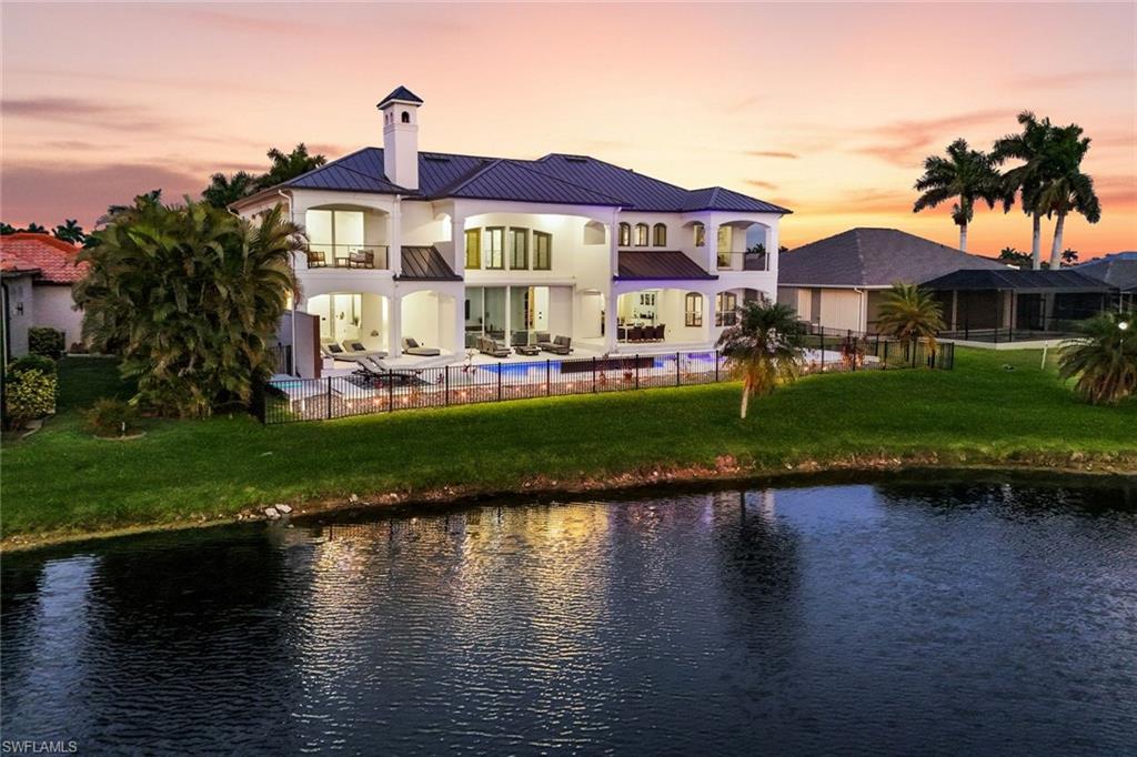 Experience timeless sophistication at this extraordinary residence masterfully updated and nestled behind the gates of the highly sought-after Cape Royal Golf Club community. Blending striking architectural design with modern elegance, this impressive estate offers more than 5,800 square feet of luxurious living space, 7 bedroom, 5 baths, 3 car  designed for both everyday comfort and unforgettable entertaining. From the moment you arrive, the home’s commanding presence makes a lasting impression. A sleek standing-seam metal roof installed in 2022, fresh contemporary exterior finishes, lush tropical landscaping, and grand entry columns create exceptional curb appeal. The dramatic double staircase and elegant foyer chandelier welcome you into an interior defined by soaring ceilings, expansive living spaces, and impeccable craftsmanship throughout. Designed with both functionality and style in mind, the open-concept layout seamlessly connects formal gathering areas with relaxed living spaces, creating the ideal flow for entertaining. The gourmet kitchen serves as the centerpiece of the home, showcasing custom cabinetry, premium quartz surfaces, high-end appliances, an oversized waterfall island with cooktop seating, and a generous pantry. Every element has been thoughtfully selected to deliver a perfect blend of luxury and practicality. Expansive pocketing sliders open completely to a stunning outdoor retreat where indoor and outdoor living become one. The spacious covered lanai overlooks a resort-style pool with fountain and 12 person spa surrounded by meticulously maintained landscaping, offering complete privacy within the fenced backyard. Western rear exposure captures breathtaking sunset views across the tranquil lake and rolling golf course fairways, creating the perfect setting for evening gatherings or peaceful relaxation. Other upgrade include Halo water treatment system.  Cape Royal boasts a 27-hole public golf course recently upgraded with irrigation, tee boxes, bunkers, and refurbished greens, along with a clubhouse restaurant and bar, tennis courts, and pickleball courts offering an active and vibrant lifestyle. Residents enjoy an equity ownership in the golf course  and rare advantage of low HOA fees with no mandatory golf membership requirements. Just moments from waterfront marinas, fine dining, boutique shopping, and world-class fishing, this exceptional property delivers the ultimate Florida lifestyle, every day feels like a luxury retreat.