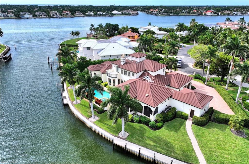 Custom waterfront home on one of the largest lots in Royal Harbor with direct access and views of Naples Bay. Set on .52 acres with more than 250 ft of water frontage, this quiet cul-de-sac location with a southern exposure is a boater's dream. Complete with a new seawall, a 50 foot dock and two boat lifts, seconds to Naples Bay and minutes to the Gulf of Mexico! This two story, 5400 S.F. home with air conditioned four-car garage's has been professionally updated in 2019, including a new roof, new four zone HVAC, new Elan home control system, interior and exterior paint, new quartzite kitchen island, countertops and backsplash and updated bathroom fixtures and lighting. Embrace the Florida lifestyle with the expansive covered lanai area and large infinity-edge saltwater pool and spa. Perfect for entertaining, the home features soaring ceilings throughout with a fireplace in the living room and study, a formal dining room, breakfast nook, wet bar, and family room. The first-floor owner's suite provides a serene escape with his and her bathrooms and walk-in closets. Located just minutes from downtown Naples and the Gulf beaches, the coastal lifestyle awaits. Enjoy Matterport Viewing