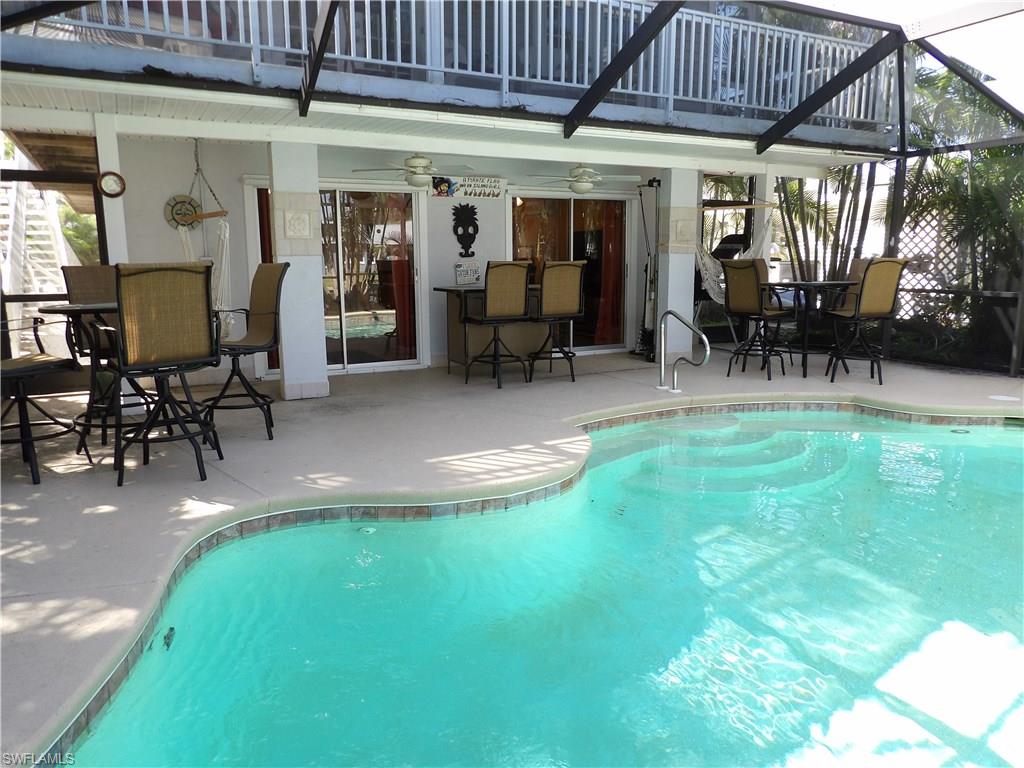 REDUCED....REDUCED.....AND REDUCED... Gorgeous island home- perfect for entertaining- the best of island life! Quick Gulf access on intersecting canals. Lovely tropical and stone landscape. First floor specifically designed for entertaining and family fun, with living area, full kitchen and double sliders out to lanai and heated screened pool. Second floor boasts living room with double French doors which open to full length screened porch overlooking canal, a fully remodeled kitchen with granite and stainless appliances, two bedrooms and an updated bathroom. Third floor features a lovely, private master bedroom and beautiful remodeled bathroom. Hurricane-resistant Bahama shutters on upper floors; Hurricane-rated garage doors and panels for bottom floor. Pool and porch screening redone in 2014 with 20/20 screening.  Aluminum rails surround second floor walk-around decking. Double driveway into lush palm lined lot. House captures tropical breezes with cross ventilation. Covered 8k boat lift and full length dock. This home is beautiful...make your appointment today!