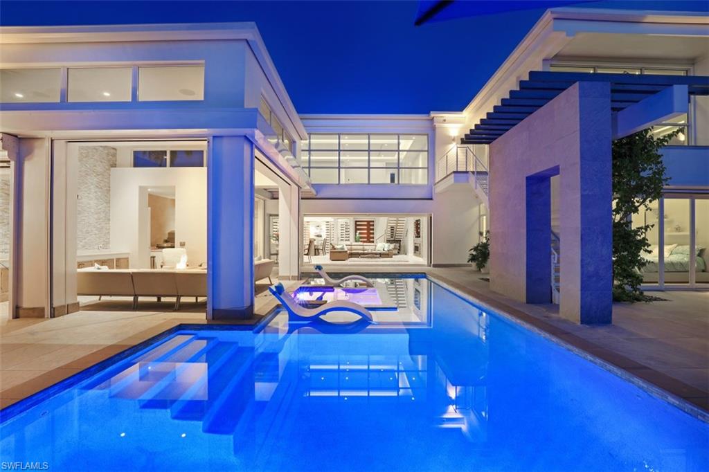 Prime location-walking distance to the upcoming 4 Season Resort, Naples Beach and shopping. Immerse yourself in the luxury of this MHK-designed home with European finishes and a sparkling pool. 4,500 sqft of space with 4 bedrooms + den, 6 bathrooms and multiple living areas. A highlight of the home is the wine room that can house 1,200 bottles plus Imperial sized bottles. Floor-to-ceiling impact windows and doors ensures an abundance of natural light that illuminates the stunning interior. A serene and neutral color palette has been paired with gorgeous hardwood flooring to ensure timeless elegance. The kitchen is equipped with Miele appliances and quartz countertops while the avid entertainer will adore the open-concept layout that flows to the rear patio with outdoor kitchen and a gas heated pool and integrated spa. From the stunning mahogany and stainless steel front door to the automatic Hunter Douglas shades and central vac system, no detail has been overlooked in the creation of this luxurious haven. Laundry rooms on each level as well as a security system, Lutron lighting and Sonos surround system for the ultimate entertainment experience. Can be sold turn key.