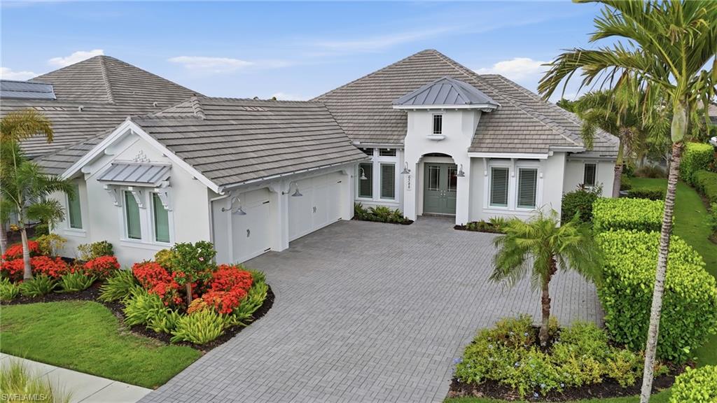 Located in the Isles of Collier Preserve, this beautifully appointed lakefront residence stands out for its exceptional attention to detail, thoughtful design, and seamless indoor-outdoor living. The 3-bedroom plus den, 3 full and 2 -bath home shows like a model, with soaring ceilings, extensive millwork, designer lighting, plantation shutters, and architectural details throughout.  The heart of the home is the expansive great room, where a dramatic custom coffered ceiling with inset tongue-and-groove detailing creates a striking focal point. The open kitchen features crisp white cabinetry, a large center island with seating, generous storage, and an easy connection to the dining room and main living areas.  Pocketing sliding glass doors open the great room completely to the covered lanai, creating one continuous living and entertaining space. The outdoor area is designed for year-round enjoyment with multiple seating and dining areas, a built-in bar, wood-detailed ceiling, pool and spa, and peaceful lake views.  Additional highlights include a private den, beautifully detailed dining room, spacious bedroom suites, a powder bath accessible from the outdoor living area, and an oversized three-car garage. The home’s coastal architecture, paver driveway, lush landscaping, and lakefront setting create impressive curb appeal from the moment you arrive  Offered furnished and meticulously maintained, this home combines refined finishes with a relaxed Naples lifestyle in one of the area’s most sought-after communities. Residents of Isles of Collier Preserve enjoy resort-style amenities, dining, fitness, pickleball, tennis, kayaking, miles of walking and biking trails, and a setting surrounded by nature, all just minutes from downtown Naples and the beaches.