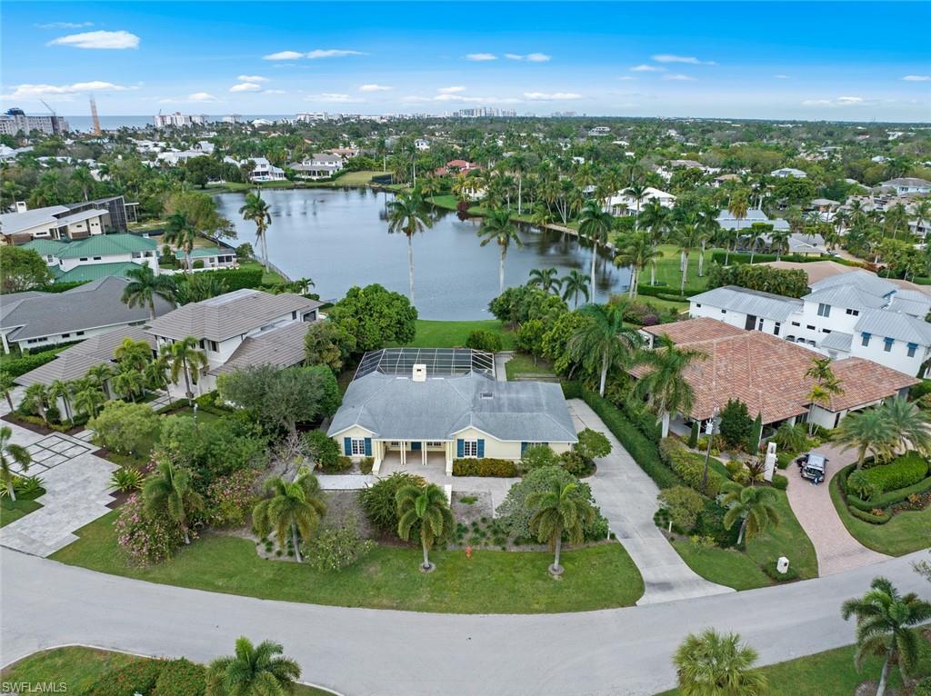 Nestled in the in vibrant heart of town this exquisite home offers a charming and timeless opportunity that is truly unparalleled. Imagine waking up each morning and strolling along the pristine beaches just a short walk away. Or indulging in the world-class amenities of the newly built Four Seasons resort. Downtown Olde Naples and the renowned NCH hospital are within a few blocks. Situated on a sprawling lot with breathtaking long lake views, the possibilities are endless. Whether you choose to embark on a new construction project or initiate a remodel, this prime location offers the perfect canvas to create your dream home. The 1957 residence features three bedrooms, two baths, adorned with stunning vaulted ceilings and numerous timeless built in bookshelves. The centerpiece of this oasis is the large pool and patio area, perfect for entertaining guests or simply basking in the Naples sun. Additionally, a detached one-bedroom guest house provides the ultimate privacy and comfort for your visitors. Embrace the Naples lifestyle in all its glory, and seize the opportunity to call this one-of-a-kind property your own. Don’t miss out on this location!