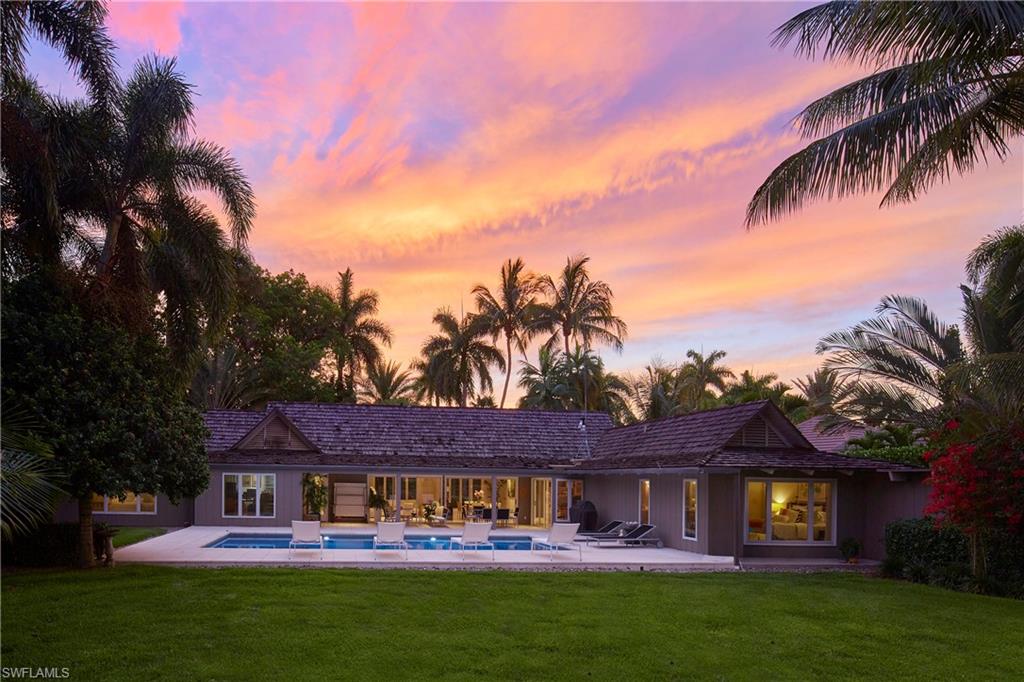 Nestled in quiet Coquina Sands and offering a serene lake and golf course view beyond, this property is truly one of a kind.  The oversized, sprawling lot with mature landscaping surrounding affords a panoramic setting and a buildable envelope to bring nearly any design to life. The charming home is a perfect place to keep while you develop your dream plan and offers a beachy vibe with lots of glass to bring the outside in and enjoy the views now. Just under a half mile to Lowdermilk Park beach, a quick drive to downtown or north Naples and on a secluded part of Yucca Rd with unique and expansive vistas, this is not the one to miss.