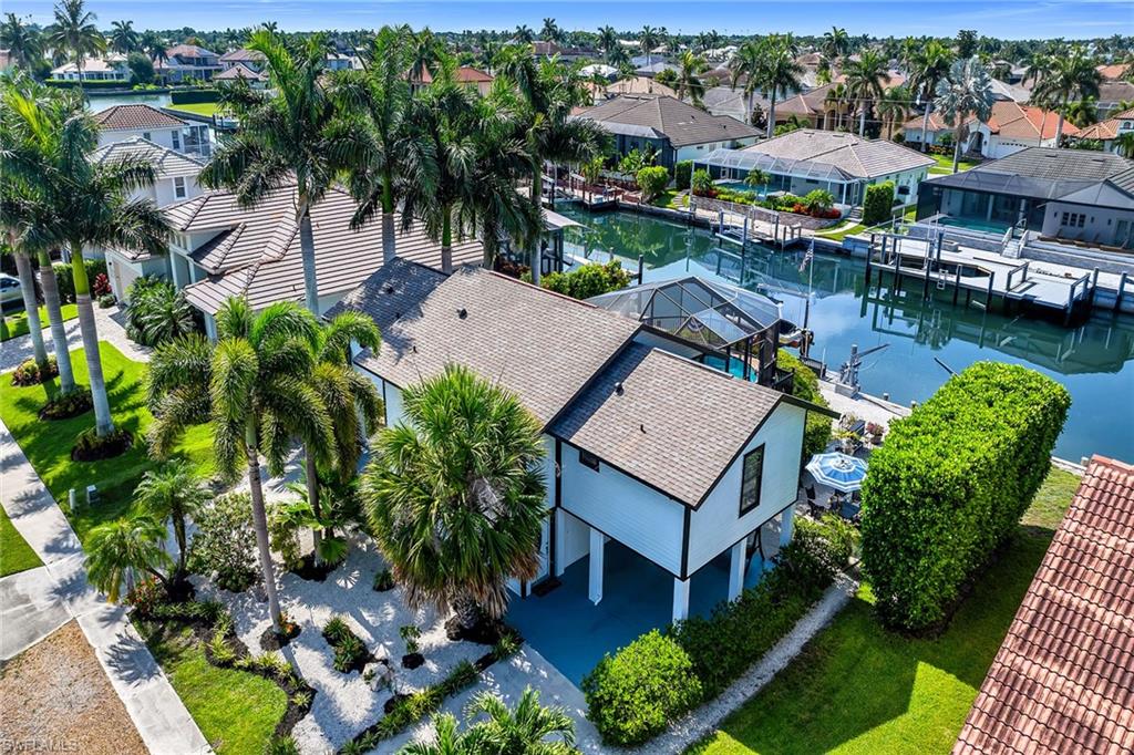 Boasting sought-after southern exposure on a peaceful canal with Gulf access, this elevated stilt home sits less than one mile from Residents’ Beach — perfectly positioned in one of Marco Island’s most desirable waterfront communities.

Ideal for builders, investors, or vacation home buyers, this property offers immediate enjoyment plus exceptional redevelopment potential. Enjoy a private boat dock with lift, heated pool, and screened lanai with beautiful canal views.

The upper main living level features 2 bedrooms, 2 full bathrooms, bathed in natural light. Bright, open living spaces, tile and vinyl flooring, and seamless indoor-outdoor flow via the lanai make it perfect for relaxed island living and entertaining. 

The finished lower level provides flexible bonus space for recreation, guests, or storage (non-conforming and not included in the home’s insurable living area).

With prime southern exposure for maximum sunshine and warmth, Gulf access, quick beach proximity, and strong upside potential, this canal-front stilt home delivers the ultimate Marco Island lifestyle — ready for you to enjoy today or reimagine for tomorrow.