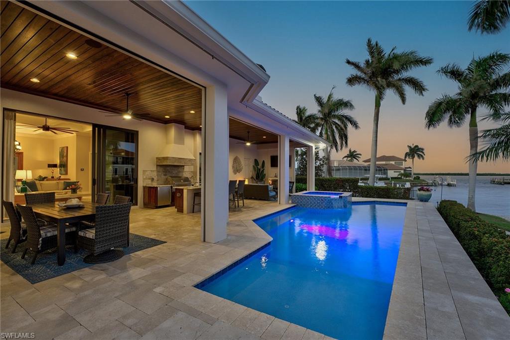 This four-bedroom, 4.5-bath waterfront retreat ideally blends luxury, comfort and breathtaking scenery. The primary suite on the main level offers privacy and indulgence, with serene water views and a spa-like en suite. The great room, complete with a fireplace and expansive windows, flows effortlessly into the stunning dining room and state-of-the-art kitchen, featuring quartz countertops, top-of-the-line appliances and an oversized walk-in pantry. A cozy den provides a quiet escape or functional office space. The second floor elevates entertainment with an upstairs media room, flanked by two additional bedrooms that each feature access to their private lanais. Every room is designed to maximize the forever water views, creating a serene connection to the surrounding natural beauty. Step outside to the lanai with a fireplace, leading to an incredible pool and spa and a fully equipped outdoor kitchen, a haven for relaxation and hosting. The private dock offers quick access to the gulf, completing this professionally designed, waterfront masterpiece. Offered turnkey furnished for your convenience!