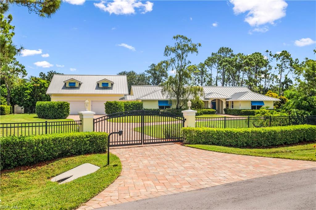 H2932 - This private gated & fenced 1.24 acre estate in Pine Ridge Estates was rebuilt, remodeled and expanded in 2016 to 5832 sq. ft. which includes a 5 car garage, 1200 sq. ft of air conditioned storage, laundry, room, new metal roof, 1 bedroom/1 bath furnished apartment w balcony and private entrance overlooking Lake Bunting. A circular driveway leads to the front of the home which has a nice sized front porch with tongue & groove ceiling.  This home has underground utilities and is on city water with lake fed sprinkler system for landscaping.  The expansive master suite includes 2 master bathrooms, and custom closet. A beautiful 3 way fireplace is centered around the living room, dining room and kitchen  and is a great gathering place. There is a 1,000 gallon propane tank which heats the pool and fireplace and the house is wired for a future generator and dog watch fence.  This home is centrally located and minutes to Mercato, Waterside Shops, dining, entertainment and the beach.  This is a one of a kind property with a beautiful 40 ft. pool and spa on a much desired private lakefront property.  In total 4 bedrooms, den, 4 1/2 baths & storage galore.