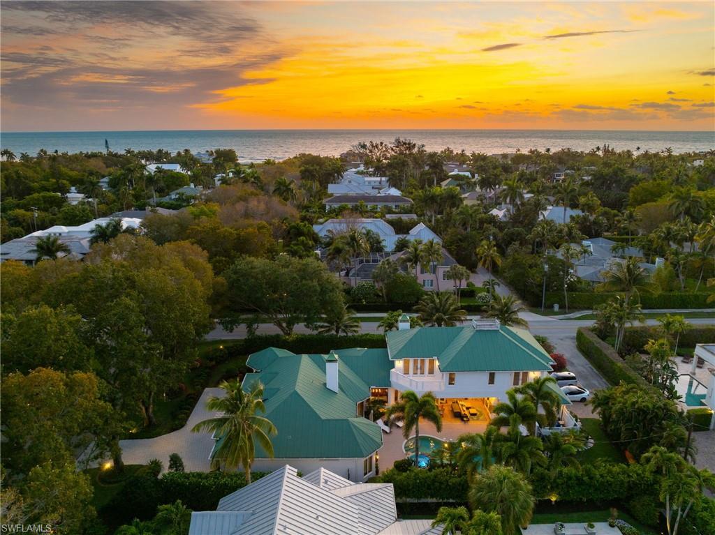 High and dry, Confirmed home elevation of 11'7". Rare oversized home site in X500 Flood Zone! Only 9 homes from the best beach in Naples. No water inside home, garage, or pool during hurricanes Ian or Milton. 11' above sea level. Prime opportunity to own a private residential property of substantial size in one of the most coveted locations in the United States. Situated on an oversized .34 acre corner homesite just steps from the beach, this residence offers 4 beds, 4 full and 2 half baths, a large office overlooking the pool, a loft, an upstairs kitchenette, 2 balconies, and multiple covered outdoor living areas including a gazebo. 12' ceilings on the entire main level. The master suite includes a morning coffee/beverage bar, his and her closets with a second laundry room, and a large bathroom with separate water closets and a bidet. The expansive layout offers ample space for everyone to spread out and unwind. Enjoy the luxury of natural hardwood floors, beautiful ceiling inlays, 2 fireplaces, impact glass throughout, a walk-in wine room, an instant-hot water circulator, and the convenience of a private elevator. The open kitchen is equipped with top-of-the-line appliances, including a natural gas stove. The heart of the home is the outdoor entertainment space featuring a resort-style pool with a spillover spa and rock waterfall. Outdoor space also offers a dedicated pool bath. This full corner parcel is surrounded by tropical foliage creating a serene oasis. A rare large back and side yard, along with a 3-car garage, add to this exceptional property's appeal. Located just a short stroll away from a very private stretch of beach (approx 1 block). Enjoy endless shopping, dining, and entertainment options at 3rd St S and 5th Ave, all within a few blocks from your doorstep. Don't miss the chance to own this gem in the heart
of paradise. Check out the property video production link.