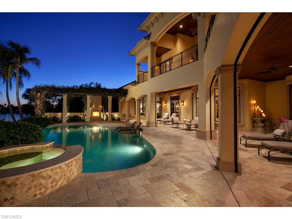 Elegant, Tuscan-style, waterfront home located in Marco Island’s exclusive Estates community features panoramic SE bay views with extensive high-end fixtures and finishes. Beautifully appointed outdoor spaces include infinity edge pool, spa, and expansive terraces with outdoor kitchen and fireplace. Extraordinary architectural details include barrel and tray ceilings, travertine and wood floors, custom built-in cabinetry, arched windows, and crown molding with 11-inch baseboards. Exceptionally designed gourmet open kitchen is the heart of the home, with Wolf stove, double wall ovens, Sub-Zero refrigerator, refrigerator drawers and two Bosch dishwashers with a Butler’s pantry and additional hidden pantry. First floor includes master suite with exercise room and additional guest suite. Upstairs loft and suites all enjoy balcony access. Additional designer spaces include library and elegant wine vault. Security system, impact windows, retractable screens and shutters. Convenient elevator access plus central vacuum system. Most furnishings included. Boaters have 5-minute direct Gulf access and large dock with lifts for a boat and two jet skis.
