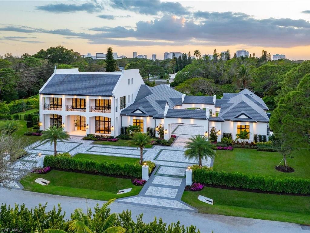 An exceptional new construction estate at 117 West Street in Pine Ridge Estates sets a striking new benchmark for refined Naples living, where timeless architectural character meets a fresh, contemporary layout designed for today’s most elevated lifestyles. Envisioned by GNR Developers, thoughtfully designed by Unique Hite Designs, meticulously constructed by The Glendale Group of Southwest Florida, and beautifully curated by AZ Designs, this residence reflects the remarkable craftsmanship and aesthetic precision each is known for. Classic architectural detailing blends seamlessly with expansive, light-filled interiors, creating a home that feels both sophisticated and welcoming. Generous ceiling heights, large window expanses, and an effortless flow between indoor and outdoor spaces define the overall design. The gourmet kitchen serves as a dramatic centerpiece, appointed with premium Wolf, Miele, and Sub-Zero appliances, custom cabinetry, and a spacious layout designed for both everyday living and entertaining. A fully equipped prep kitchen adds another layer of convenience and refinement for hosting on any scale. Outdoor living is equally compelling. The resort-style pool and spa anchor a spectacular backyard setting framed by lush green space, multiple covered and open-air lounging areas, and an impressive fire pit gathering space designed for evenings under the Naples sky. The thoughtfully arranged floor plan offers three bedrooms on the main level and three additional bedrooms upstairs, complemented by a spacious bonus living and game area. A  separate guest casita provides an exceptional private retreat with its own living room, kitchen, and utility space. For the automotive enthusiast, six garage bays with lift-height clearance and a generous motor court provide rare flexibility and scale. Set within the expansive estate lots of Pine Ridge Estates and moments from Naples’ celebrated dining, beaches, and cultural destinations, this remarkable property offers an extraordinary opportunity to experience luxury living at its most thoughtfully designed.