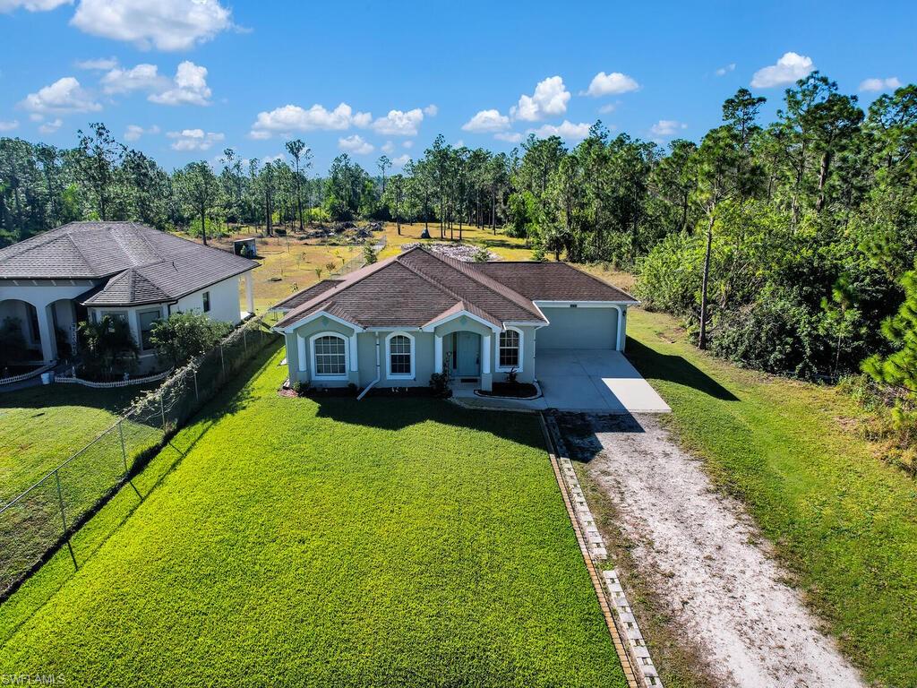 PEACEFUL COUNTRY SETTING! Single family home on one 1.14 acres of land w/ comfortable layout- living & family room design, newer a/c unit, spacious kitchen w/ island, tile flooring in main living areas, split bedroom floor plan, laundry set-up in garage, open rear lanai, fenced-in backyard, long driveway w/ lots of parking area, and plenty of room to add detached garage/pool/workshop. Situated in BEST & fast-growing area of Naples that is off of Everglades Blvd N having easy access to I-75, close to Ave Maria, short drive to tons of shopping/dining options, and is only 45 minutes from the beaches of SWFL.