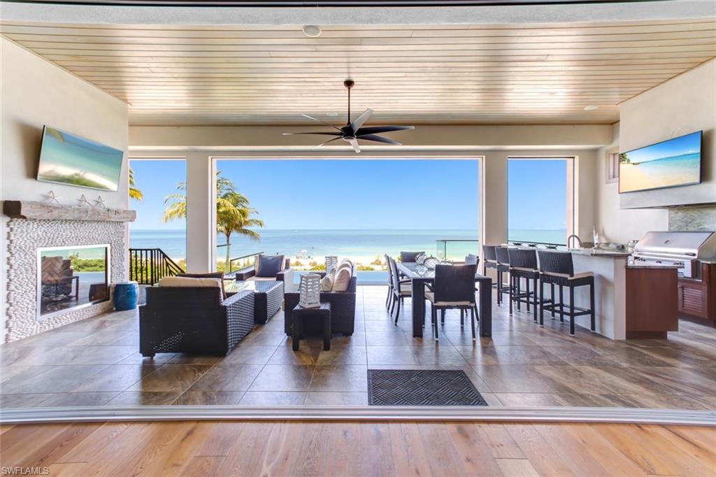 Direct beachfront, recently constructed, state-of-the-art masterpiece, with high-end coastal contemporary finishes & panoramic Gulf views as the backdrop. Incredible open floor plan highlights the beachfront setting, with fully pocketing sliders that open to the elevated entertainment deck with dramatic infinity edge pool & spa, summer kitchen with gas grill & fireplace, all overlooking the Gulf.  This 5 bed + den, 5.5 bath home boasts an extra-spacious master suite, garages with room for 6+ cars, double laundries, a private elevator to all floors and an incredible top-floor bonus entertainment room with second wet bar. No details overlooked with white oak hardwood floors, volume ceilings with stunning details, designer lighting features & all quartz/granite counters. Professional kitchen features Wolf & Thermador appliances, eat-in island & separate bar with seating for 5. Also includes impact doors/windows & Control4 automation system for climate, security, shades, shutters, lighting & music. Ideally located minutes to Mercato & North Naples’ amenities with easy access to I75 & the International Airport. Enjoy the best of the best; all overlooking the stunning Gulf of Mexico.