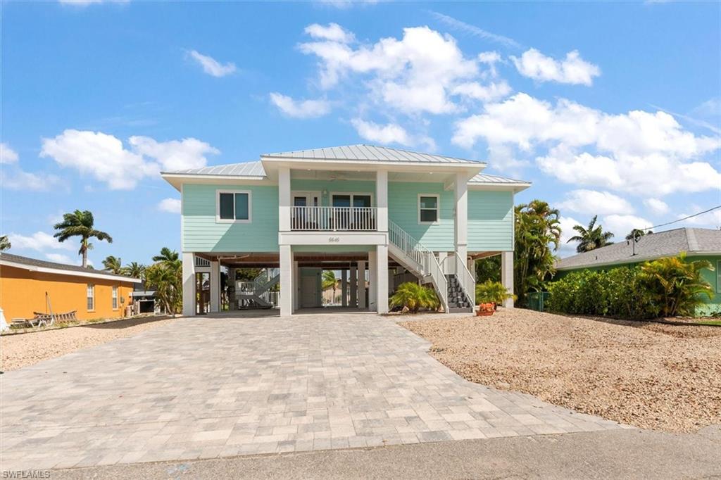 Newly built elevated gulf access pool home located in the desirable Holiday Heights neighborhood on Fort Myers Beach.  Completed in 2025 and gently used since, this 3 bedroom 2 bathroom home offers a coastal feel with quality design and beautiful finishes.  You may ascend to the living area using 1 of 2 composite staircases or call for your private elevator to transport you up to the property.  Once inside you will admire the great room, teeming with natural light through the impact windows, complete with formal dining for 10, a comfy yet sophisticated living room, and sensational kitchen outfitted with stainless steel appliances, marble island, wine fridge, and 4-person breakfast bar.  The spacious primary bedroom, with pocket sliders leading out to the deck and ensuite bathroom, provides a quiet sanctuary for the owners.  You will find 2 guest bedrooms separated by a beautifully appointed bathroom on the other side of the home, perfect for families or guests.  Once back downstairs and outside you can enjoy a large heated saltwater pool with sun shelf overlooking the canal with views of the bay.  When you are ready to hit the water, the newly constructed dock with electric boat lift is the perfect spot to store your vessel.   This beach property is located just minutes from Publix , shopping and dining options of Santini Plaza, and the Margaritaville Resort.