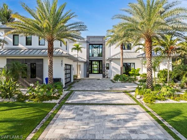 Step into refined waterfront living with this exceptional 4-bedroom, 6-bath estate offering 155 feet of direct Gulf access. This beautifully designed modern home sits on an oversized corner lot in Royal Harbor. Fully furnished and move-in ready, the home blends timeless design with modern features—marble and wood floors, a chef’s kitchen with Wolf and Sub-Zero appliances, and a separate service kitchen. The expansive outdoor space showcases a negative-edge pool, spa, outdoor kitchen, and dramatic landscape lighting with over 80 fixtures. Smart home systems include Lutron lighting, Elan control, a glass elevator, and full security. A private guest suite with its own entrance, half kitchen, and alarm system offers ultimate flexibility. Two boat lifts that are up to 24,000 lbs and just minutes from Naples' world-class dining, shopping, and beaches.