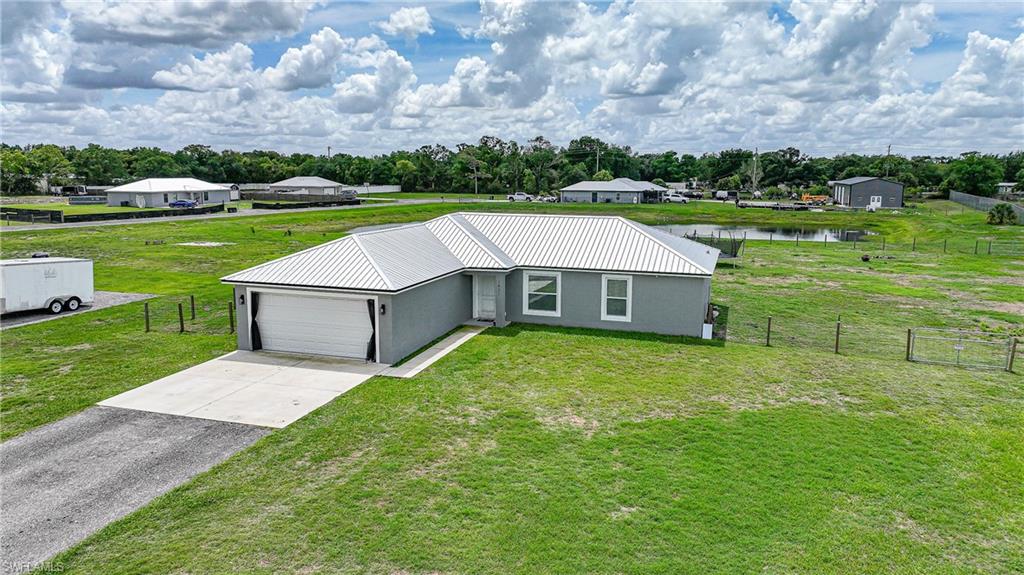 Welcome to this beautifully constructed 2023 home, offering the perfect blend of modern comfort and open space in desirable SE Arcadia. Situated on a sprawling 1.55-acre lot, this 3-bedroom, 2-bathroom residence with a 2-car garage offers 1,910 gross square feet and the ideal balance of privacy, functionality, and newer construction. Designed for both everyday living and entertaining, the home showcases a popular open split floor plan enhanced by high ceilings and luxury vinyl plank flooring throughout. The living, dining, and kitchen areas flow seamlessly, making the layout as practical as it is inviting. At the heart of the home, the well-appointed kitchen features crisp white shaker-style cabinetry, sleek dark hardware, stainless steel appliances, and a timeless subway tile backsplash. A large center island with generous counter space is perfect for meal prep, casual dining, or gathering with friends and family, while stylish pendant lighting adds warmth and character. Ample cabinetry and counter space provide excellent functionality while keeping the kitchen connected to the main living areas. The laundry room is conveniently located off the dining room, offering practicality without disrupting the flow of the home. The primary suite is complete with a spacious walk-in closet accented by a sliding barn door.  The ensuite bathroom delivers a spa-inspired experience with a dual-sink vanity, granite countertops, white cabinetry, matte-black fixtures, a large mirror, and modern lighting. The generously sized walk-in shower, featuring beautiful tile work and decorative accent inlays. Two additional guest bedrooms are thoughtfully positioned on the opposite side of the home, each with nicely sized built-in closets, and they share a well-appointed full guest bathroom. The 2-car garage is fully air-conditioned, adding comfort and versatility for projects, storage, or daily convenience. Outside, enjoy peaceful country living with room to spread out. The partially fenced backyard (not the entire property) includes dual gates, creating a defined area perfect for pets, play, or outdoor gatherings, while the remainder of the lot offers plenty of space to expand, garden, or simply enjoy your surroundings. At the rear of the property, a serene pond shared with the neighboring parcel enhances the tranquil setting and provides scenic backyard views. With generous spacing between neighbors, open skies, and a quiet location, this home offers privacy, flexibility, and the convenience of modern construction. Ideally situated in the heart of Arcadia, this property offers convenient access to everyday essentials and local favorites. Grocery stores and a variety of dining options are just minutes away, making daily errands a breeze. Enjoy the convenience of Brewer Park, located just one street over from the home. The home is also close to DeSoto County High School and other nearby schools.