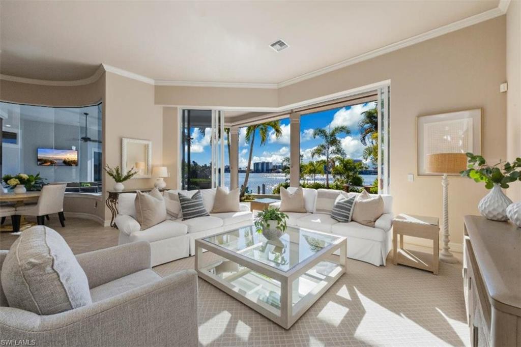 Enjoy breathtaking, picture-perfect sunsets from this prime Moorings waterfront residence. Featuring 103 feet of deep-water frontage and direct, no-bridge access to the Gulf, this home provides an exceptional boating lifestyle paired with a lush privacy-oriented yard, pool and spa deck. With a half mile of sweeping, panoramic views across Moorings Bay sitting on one of The Moorings’ coveted ‘Nifty Fifty’ waterfront parcels, the property blends modern updates with timeless Florida-coastal style. The beautifully updated kitchen serves as a bright and inviting centerpiece for everyday living and entertaining, and with a 10’ high x over 20’ wall of glass pocket sliders, it offers a seamless indoor–outdoor experience. The first-floor primary suite is generously sized and enjoys beautiful views of the water, while the reimagined primary bathroom provides a sleek, spa-inspired retreat with refined finishes. The first floor also includes two additional guest rooms plus an office or den retreat. The second floor features a private two-room guest suite with full bath, a layout designed for generations of the entire family to enjoy. Expansive windows and glass sliders throughout the home frame the tranquility of the bay and the stunning sunset backdrop - fully equipped with electric storm shutters and a lanai enclosure. Surrounded by brand new limestone pool decking, a classically graceful pool and spa await. The expansive dock extending past the rear yard is equipped with lighting, power and water, a boat lift, two jet ski lifts, additional docking space for visitors or recreational watercraft, creating a true waterfront haven. Walk, bike or drive in minutes to the Moorings Private Beach Park, an unbeatable convenience in this highly sought-after neighborhood. Move right in and enjoy effortless coastal living, whether relaxing by the pool, hosting guests, or heading out on the water. Located on a private street, this residence offers the ideal blend of luxury, comfort, and the quintessential Naples waterfront lifestyle.