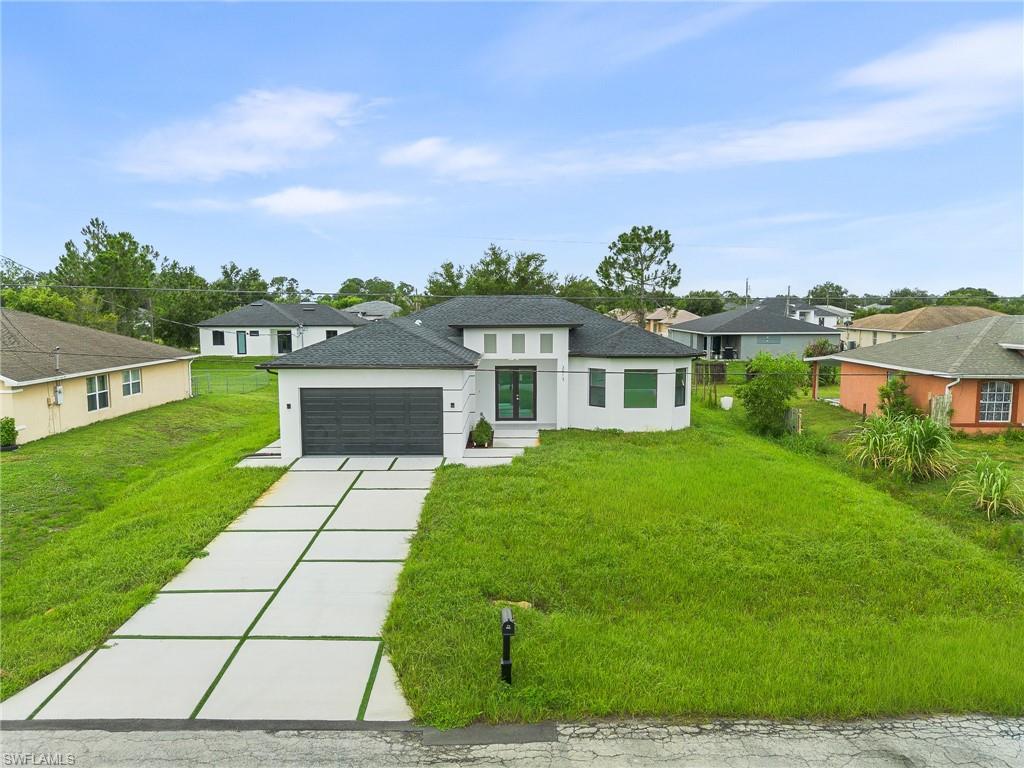 Stunning brand-new 2025 construction in Lehigh Acres! This 4-bedroom, 2-bathroom home offers 1,714 sq ft of thoughtfully designed living space with soaring high ceilings and an open-concept layout. The gourmet kitchen is a showstopper, featuring a granite island, floor-to-ceiling cabinetry with abundant storage, and a panoramic window that opens to the outdoors — bringing in natural light and seamless indoor-outdoor living. Elegant porcelain tile flows throughout, and every bedroom offers spacious walk-in closets. Step outside to a covered lanai complete with an outdoor kitchen, perfect for entertaining year-round in the Florida sunshine. Built for durability and peace of mind with impact-resistant windows and a shingle roof, plus a modern, upscale driveway that elevates the home’s curb appeal. NO HOA and no rental restrictions — ideal for homeowners and investors alike. Centrally located with easy access to shopping, dining, schools, and I-75. Move-in ready — don’t miss this one!