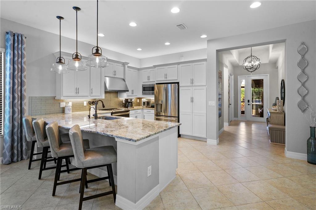Welcome to 10092 Windy Pointe Court, an exceptional residence in the Marina Bay community where luxury, privacy, and meticulous craftsmanship converge. Perfectly positioned on one of the largest and most desirable homesites in the neighborhood, this Cayman floor plan offers an unparalleled outdoor living experience with an expansive rear overlooking a tranquil preserve.  From the moment you arrive, the home's impeccable condition and extraordinary attention to detail are immediately apparent. Offering 2 bedrooms + den, 2.5 baths, and 2,200 square feet of thoughtfully designed living space, every element has been carefully curated to enhance comfort and sophistication.  The true centerpiece of this property is the resort-inspired outdoor sanctuary. An expansive screened lanai showcases a sparkling saltwater pool and spa (Pentair quality equipment), a fully equipped outdoor kitchen, and breathtaking preserve views that create a serene backdrop for entertaining or everyday relaxation. Beyond the pool, a private fenced area provides additional space for pets while preserving the home's open, estate-like feel.  
This distinguished residence is further enhanced by an impressive collection of premium upgrades, including level 3-grade cabinetry, upgraded kitchen appliances and range hood, front and rear screened lanais, professional hardwired landscape up lighting, an epoxy-finished garage floor, Lift Master belt driven w/built in camera garage door opener, whole-house gutters, over-sized garage w/space for a golf cart or workshop, an advanced in-duct air purification system, a Complete RO system  & specialty chemical-free laundry system both by Rain Soft designed for modern wellness and convenience.  Surrounded by lush landscaping and offering exceptional privacy, this rare Marina Bay home embodies the finest in Southwest Florida living.  Residents of Marina Bay enjoy a vibrant, resort-style lifestyle with sidewalks and amenities for all ages, including pickleball and tennis courts, a fitness center, indoor and outdoor basketball courts, playground, splash pad, lap pool, and a resort-style community pool. The clubhouse offers a card room, event space, covered poolside seating, and a full calendar of planned social activities. Marina Bay delivers a beautiful, active, and relaxed lifestyle w/ low HOA dues—you don't want to miss this one!