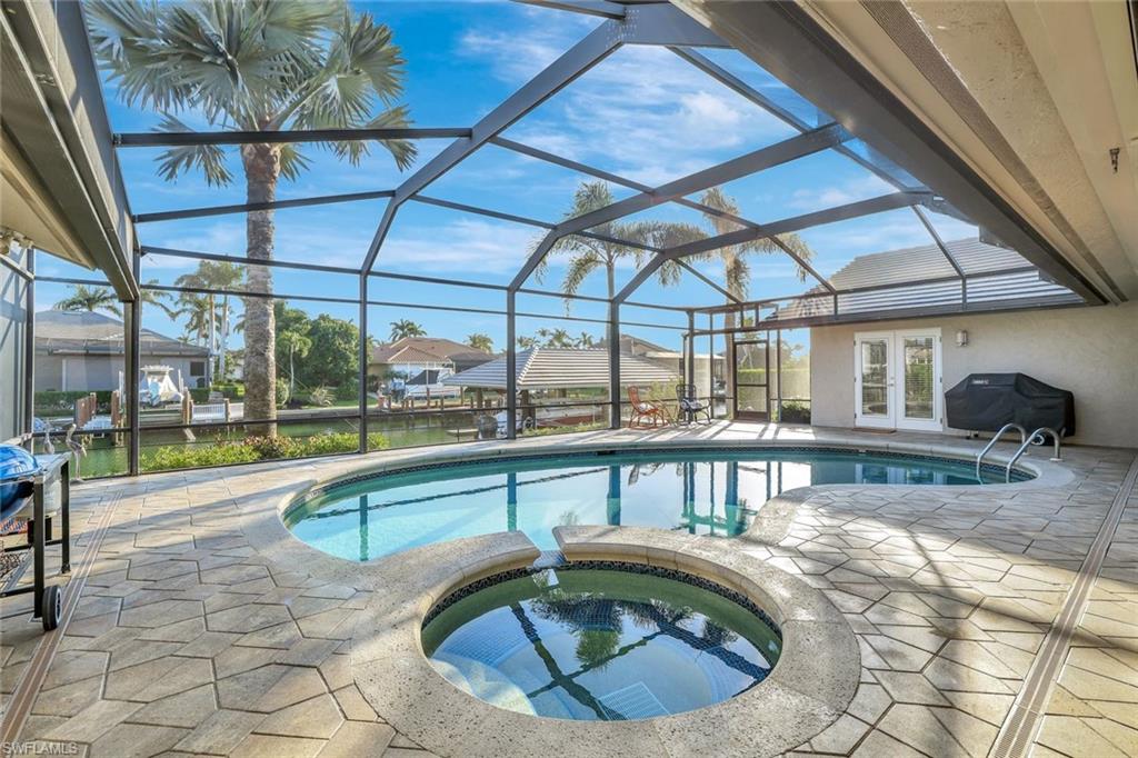 Beautifully updated waterfront home with gulf access on Collingswood Avenue. This meticulously maintained 4-bedroom, 4-bath waterfront residence located in one of Marco Island’s most desirable boating neighborhoods. Set on an oversized lot with southeast exposure, this home offers quick indirect Gulf access and a peaceful setting along a wide canal. Inside, you’ll find a bright, open layout with generous natural light, neutral finishes, and an effortless flow between indoor and outdoor living spaces. The kitchen features updated cabinetry, quartz countertops, KitchenAid stainless appliances include two dishwashers, separate ice machine, two refrigerators, plus a Thermador 5-burner gas range, and a large breakfast bar perfect for casual dining or entertaining. The spacious living and dining areas open to the lanai, creating an ideal backdrop for enjoying the water views. The primary suite offers a private retreat with direct pool/lanai access, a walk-in closet, and an updated bath. Two guest bedrooms are thoughtfully situated on the opposite side of the home, providing comfort and privacy for family and visitors. Step outside to a screened lanai with built-in firepit overlooking the sparkling pool and expansive waterfront. The property includes a dock with a RARE 14,000 lb covered lift, making it easy to enjoy boating, fishing, and exploring the surrounding waterways. Mature tropical landscaping frames the yard and enhances the home’s curb appeal. Additional highlights include a temperature-controlled wine room, impact-rated windows and doors, a 4-car garage for the car enthusiast, a tile roof, whole-house generator, Sonos sound system, storm screens on rear lanai, Kinetico water system, 500-gallon propane tank, indoor fitness room, all in a well-designed split floor plan. Whether you’re looking for a full-time residence or a vacation retreat, this home offers the relaxed coastal lifestyle Marco Island is known for—just minutes to white-sand beaches, dining, and shopping.