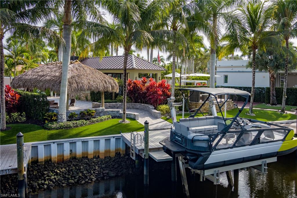 Welcome to your private waterfront retreat in Naples Motorcoach Resort, where tropical elegance meets nautical adventure.

Perfectly positioned along a serene canal with indirect Gulf access, this fully landscaped RV property invites you to live the Southwest Florida boating lifestyle to the fullest. Step onto a masterpiece of expansive paver hardscape surrounded by lush, mature tropical plantings that create both beauty and privacy. As the sun sets, the custom tiki hut glows with stunning ambient lighting, setting the stage for unforgettable evenings under the palms.

Entertain with ease in your fully appointed outdoor kitchen featuring a premium grill, generous prep space, and room for gathering. Just steps away, your oversized private dock is equipped with electric service and an impressive 15,000 pound boat lift ready for your center console, deck boat, or pontoon.

From your dock, cruise through the peaceful mangroves and rookery on a scenic 20-minute ride to Marco Island or Naples. Dock for lunch, explore your favorite beach, or simply enjoy the journey. Along the way, you’ll likely spot manatees gliding through the canal and an array of native birds soaring above the mangroves. The views from your property are unmatched—tranquil water in one direction and preserved mangrove beauty just beyond.

For those seeking something truly extraordinary, special consideration is offered if purchased together with the adjacent property, an oversized lot and a half featuring its own impressive casita, private dock, and boat lift. Create a rare waterfront compound ideal for extended family, guests, or the ultimate in the luxury motorcoach lifestyle.

Life at Naples Motorcoach Resort is equally exceptional. This gated Class A motorcoach community offers:

Three resort-style pools, including a stunning infinity pool

Three spas and a sauna

Well-equipped fitness center

Three pickleball courts

Clubhouse with seasonal events and social gatherings

Dog park for your four-legged companions

Community boat ramp with Gulf access

Beautiful Royal Palm-lined streets, fountains, and lush tropical landscaping throughout

This is more than an RV property, it’s a waterfront sanctuary where boating, nature, and resort living blend seamlessly. Cast off, cruise out, and come home to paradise.