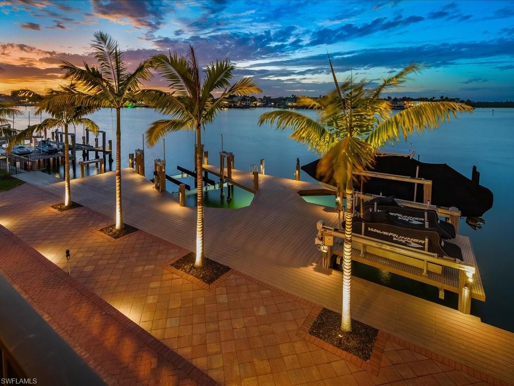 Walking distance to Tigertail Beach this Tuscan style home with ELEVATOR is situated on one of the best positioned lots on Collier Bay for gorgeous waterfront living on quiet cul de sac. Over 5100 square feet of living space, 4 bedrooms and a Den and 4 full baths, marble floors, Brazilian stone, onyx countertops, venetian plaster and faux painting. Four of the six balconies face the bay and a three story outdoor staircase descends to allow access to all outdoor areas from every level of the home. As well as Three Story Custom Staircase on interior of the home. First floor grand entry way walks out to 8 attached garage spaces. Lanai & pool with sunshelf/waterfall spa and and OVER 5000 square feet of covered lanai space perfect for outdoor entertaining.  80 foot boat dock and lift. Outdoor kitchen, breathtaking panoramic views of Collier Bay. The second floor boasts a gourmet kitchen, living room with fireplace two bedrooms, wine room, Den and Butler Style wet bar. Home has two full kitchens, one on main level part of guest quarters & on the third level with spacious bedroom, en-suite bathroom, 3 private walk out balconies & large living room. Whole house generator and 3 A/C zones.