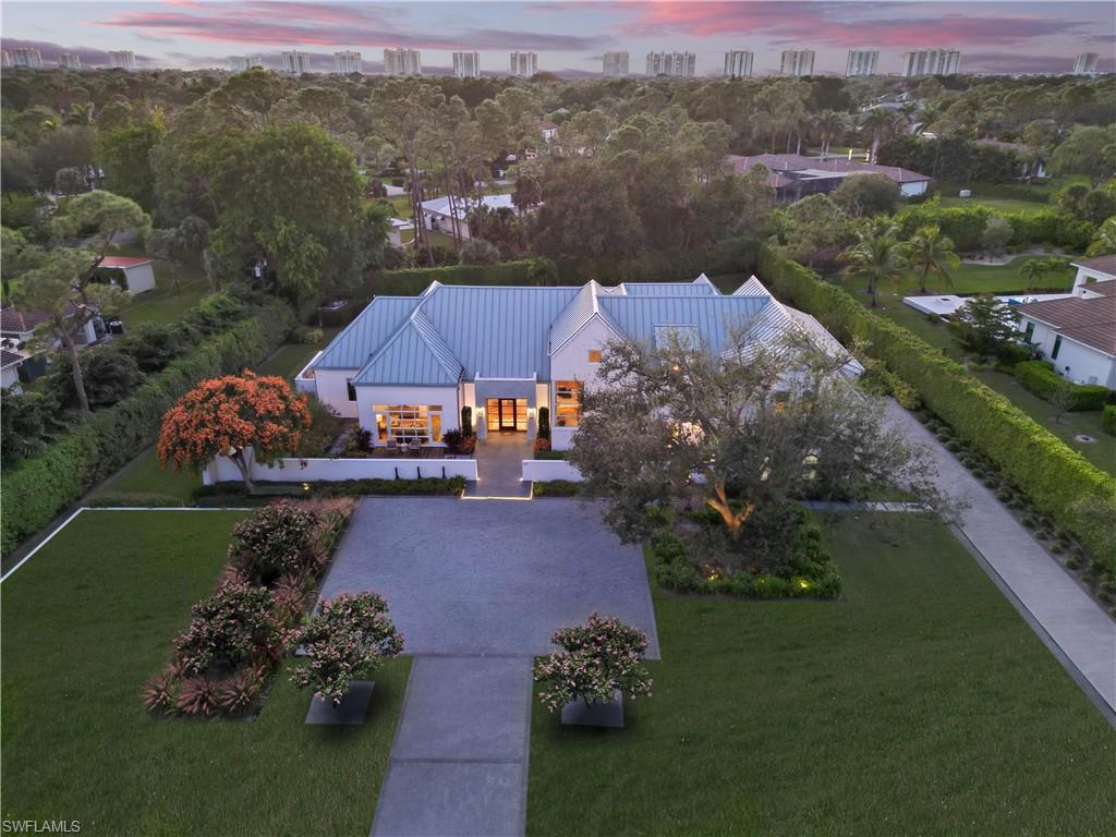 The Pine Ridge Estates neighborhood is now one of the most popular in Naples for its rural aesthetic, abundant privacy, and larger lot sizes. Its close proximity to the beach, fine dining, and shopping make for the perfect blend of serenity and activity. Not only are you across from Mercato, Waterside Shops, and Vanderbilt Beach, but you are only a 6-minute drive to 5th Avenue downtown. It is now rare to find a luxury property within this neighborhood in such a central location as 581 Myrtle Road, with no major road noise and Southwest backyard sunsets. Cited in the very center of the popular 94-acre, equestrian style neighborhood, this home has proven to be superbly resilient to hurricanes, both in expert construction and with its rare 16.3’ elevation above sea level. This is the first of several ‘Modern Farmhouse’ luxury homes in Pine Ridge from developer R.O.I. NAPLES that carved a compelling new niche in the market for unique materials, bespoke interior design finishes, and Hamptons-inspired architectural details. Winner of multiple Sand Dollar and Aurora Awards in both interior/exterior design and detailing, this is an opportunity to own a rare, New England aesthetic here in Naples. A standing seam metal roof, formed cement style portico, stucco board and batten siding, and oversize, hurricane-rated windows/doors throughout establish this bespoke style. Six Ipe decks and old growth trees compliment the 40’ pool/spa and the outdoor kitchen and living areas. Once inside, it’s the warmth of European oak herringbone floors, the artistic use of reclaimed hemlock on feature walls, and the 23’ tall pitched great room ceiling perched above your eye level that immediately halt your search for a home with an emotional connection. Not a typical 'model home' built to appeal to the masses, 581 Myrtle Road was designed to organically attract that rare and discerning buyer who walks in, recognizes that it is unlike anything else on the Naples market, and appreciates the extensive and unique luxury details throughout. Having a large ‘in-law suite’ on the first floor is perfect for visiting family members. On the second story, two ensuite bedrooms with 12’ vaulted ceilings and a family room with wet bar, optimally maximizes every inch of this near 6K square foot home which was designed and built for comfort and style. Architectural plans already drawn within the setbacks for a 2-story detached guest house.