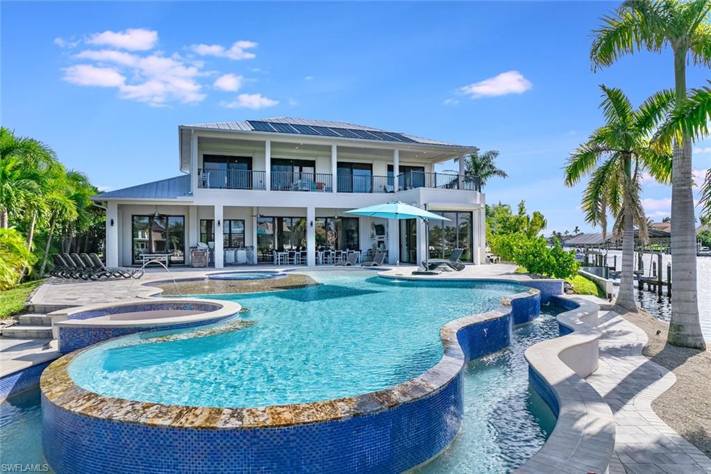 Presenting an exceptional TURNKEY opportunity, this Dream Home stands as a unique gem in Cape Coral, This 2018 build caters to aficionados of VRBO, boaters, RV'ers or the buyer with a large family. The home boasts an insulated 38’ deep garage stall, a 13,000lb covered boat lift with bait tank, ample space for an RV up to 6 cars with plenty of storage. Indulge in the pinnacle of culinary experiences with Viking Appliances, DCS outdoor kitchen equipment, all set against the backdrop of big water views. The heated saltwater pool is a spectacle in itself—expansive, adorned with  diverse water features, an infinite edge, spa, swim-up bar, sun ledge and a beach entrance. The property boasts not one, but four Master Suites, up to 7 bedrooms total, each offering picturesque water views. Additionally, find an office/in-law quarters with a separate entrance and an illuminated Granite staircase that ascends to the upper levels.Embrace effortless security with Electric Hurricane Shutters adorning all bedrooms, ensuring your peace of mind. Beyond its luxurious features, this property also holds promise as an investment opportunity, featuring every imaginable desire of a renter.