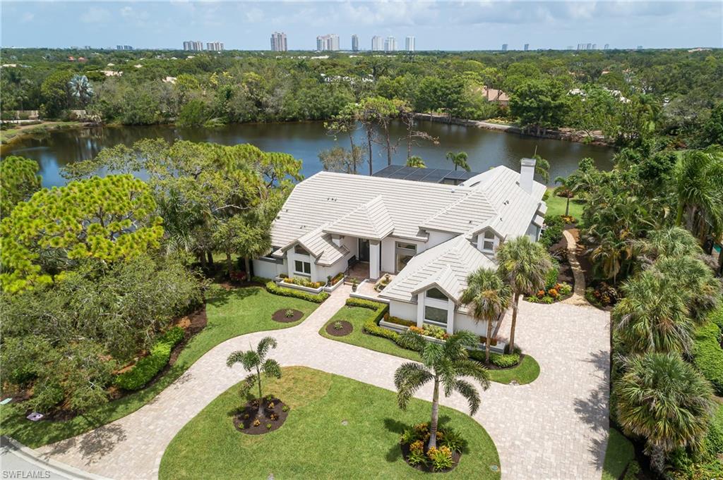 From the vantage point of this extraordinary Bonita Bay estate home, a breathtaking view awaits through walls of glass, showcasing a tranquil lake that gracefully envelopes the home.  Step inside where the living room, dining room, and large family room with linear fireplace flank the open island kitchen.  The remodeled kitchen has white custom cabinetry, glass accents, tall pantry cabinets with pull-out drawers, and center island surrounded by wrap-around marble counters. A wine cooler, beverage cooler, induction cooktop with stainless steel hood, and convection wall oven complete the chef's dream.  Outdoors the pool, hot tub, captivating water features, spacious bar, grill, prep sink, and fire pit area create unforgettable gatherings.  The palatial primary suite boasts high ceilings, 2 closets, ample walk-in shower, free-standing tub, new cabinets, and counters with dual sinks.  The home has another 1st-floor suite and a loft, plus two more suites upstairs.  Bonita Bay residents enjoy the ultimate array of amenities, including 5 golf courses, private beach, marina, resort-style pool, state-of-the-art fitness facility, luxury spa and salon, 12 miles of walking trails, and 3 parks.