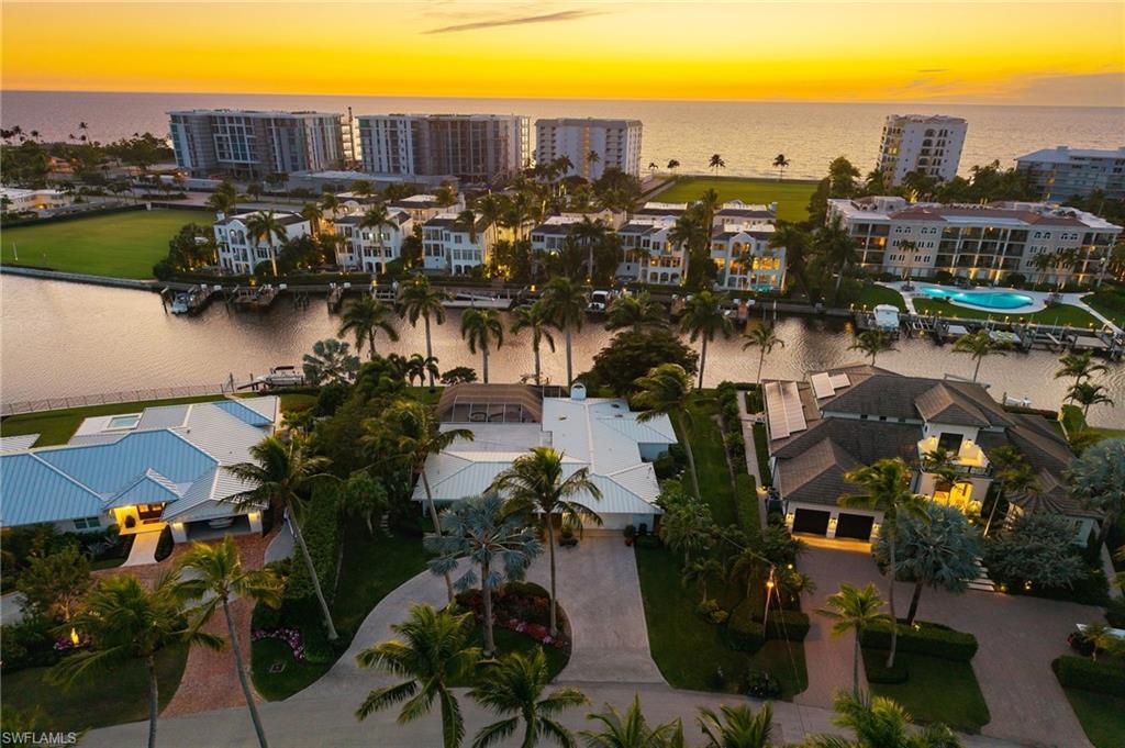 Framed by long, southwest-facing water views, this exceptional waterfront residence in Coquina Sands enjoys a tranquil setting along the quiet enclave of Hurricane Harbor Lane in Naples. Offering approximately 150 feet of water frontage and the rare luxury of sunsets year-round, the property spans just under half an acre and provides an extraordinary sense of openness and privacy, with sweeping water vistas serving as a stunning daily backdrop.
Thoughtfully oriented to embrace its remarkable setting, the home features a light, bright interior where the main living spaces flow effortlessly toward the water, creating a seamless indoor-outdoor lifestyle. Expansive windows invite natural light throughout, while tranquil water views remain the focal point from many vantage points within the home. Outdoors, a spacious pool and lounging area provides the perfect setting for both relaxed afternoons and elegant entertaining. A newly constructed seawall and private dock, completed in 2020, are complemented by a boat lift with an impressive 25,000-pound capacity—ideal for accommodating a sizable vessel and providing effortless access to the surrounding waterways for boating and paddleboarding adventures.  Additional highlights include a durable metal roof, a freshly refreshed interior, and a highly desirable lot shape and size that presents exceptional future redevelopment potential. Ideally located just moments from the sugar-sand beaches of the Gulf and the renowned dining, shopping, and cultural offerings of downtown Naples, this property represents a rare opportunity to enjoy peaceful waterfront living in one of Naples’ most coveted coastal neighborhoods.