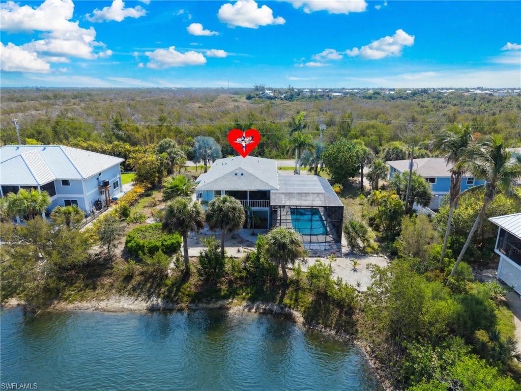 This stunning elevated island home offers the very best of coastal living, featuring a private heated pool with a dramatic two-story screened enclosure and breathtaking water views paired with unforgettable sunsets—all just minutes from the beach. Inside, a bright open-concept layout creates a spacious and inviting atmosphere. The main living area flows seamlessly onto an expansive screened lanai,effortlessly blending indoor and outdoor living while maximizing both space and comfort. Nearly every room showcases picturesque waterfront views and the surrounding natural beauty. Deeded beach access is just a short 5-minute walk at the end of the street, making it easy to enjoy Sanibel’s renowned shoreline. The property also features multiple screened decks, frequent wildlife sightings, and the rare opportunity to take in spectacular sunsets over one preserve and equally stunning sunrises over another. Extensively updated and meticulously maintained, the home includes a newer roof along with recent upgrades such as HVAC, water heater, garage doors, pool cage,luxury vinyl plank flooring, impact windows, interior doors, and composite exterior stair treads. Ideally located, you’re just moments from local favorites like Rosalita’s Cantina and the soon-to-open Bailey’s Market, as well as the Sanibel Recreation Center, J.N. “Ding” Darling National Wildlife Refuge, and miles of scenic bike paths. Impeccably cared for and move-in ready, this exceptional property captures everything that makes island living on Sanibel so special.