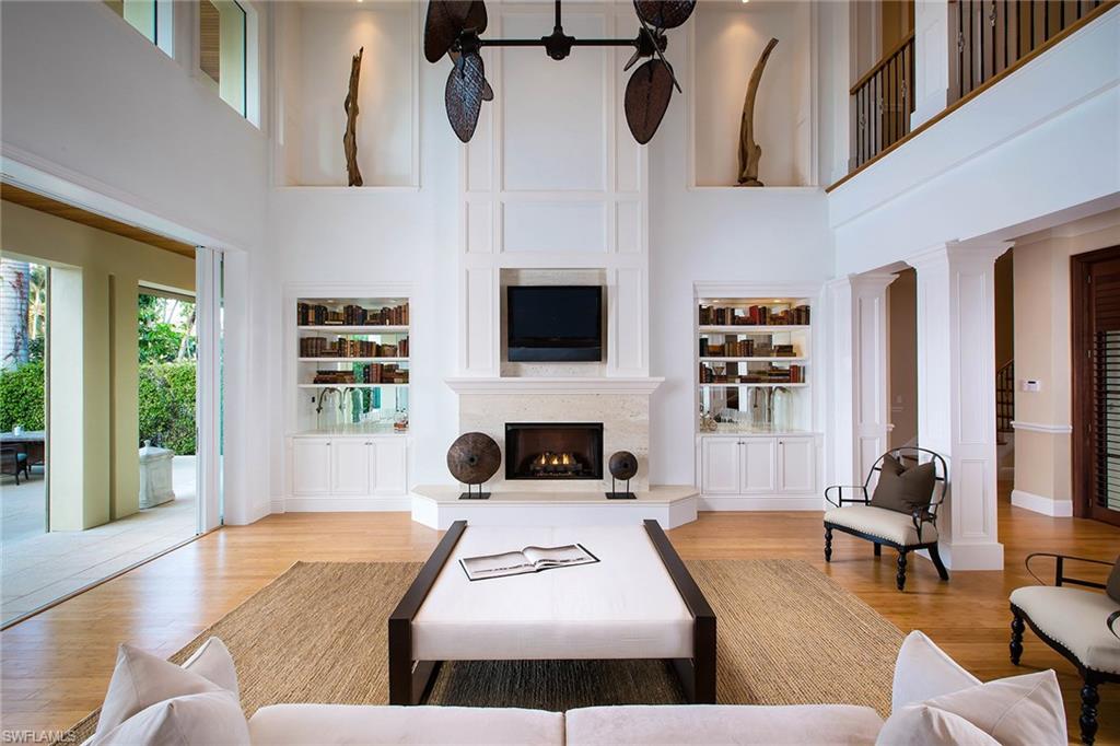 Enter into a dramatic, two-story great room designed with expansive sliding glass doors and window walls that frame glistening views of Venetian Bay and a picturesque infinity-edge pool. The open layout reveals a loft-style second floor, encircling the towering main living area while highlighting two upstairs open-air verandas. The gourmet kitchen is fitted with Dacor professional grade appliances, custom cabinetry, breakfast bar, center island with prep sink, wine fridge and butler’s pantry. Enjoy a first-floor master suite offering dual walk-in closets, bath with separate tub and shower, dual water closets and two sets of French doors opening to the first-floor veranda. This elegant home also features bamboo flooring, three fireplaces, private boat dock with lift, four-car garage capacity and a full summer kitchen.