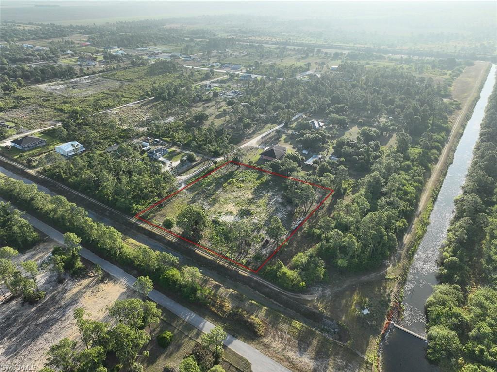 Discover the perfect blend of privacy, beauty, and country living on this stunning 2.5-ACRE WATERFRONT property in LaBelle. This one-of-a-kind lot features a PEACEFUL CANAL IN YOUR BACKYARD, creating the perfect setting to relax and enjoy nature. The property has already been beautifully prepared and improved, making it READY FOR YOUR DREAM HOME OR FUTURE INVESTMENT.
Enjoy a FULLY FENCED 6-FOOT PERIMETER with a 24-FOOT GATE ENTRANCE for added privacy and convenience. The land has been CLEARED, CLEANED, AND PROFESSIONALLY FILLED with approximately 40 TRUCKLOADS OF DIRT. Surrounded by lush landscaping, the property includes 20 ROYAL PALM TREES, 30 COCONUT PALM TREES, and OVER 200 SEVEN-GALLON CLUSIA PLANTS, creating a tropical paradise feel unlike any other lot in the area.
A SURVEY IS ALREADY AVAILABLE, saving buyers time and money. Whether you are looking to build your forever home, create a peaceful getaway, or invest in a UNIQUE PIECE OF FLORIDA LAND, this property offers endless potential and unmatched charm. QUIET, PRIVATE, AND BEAUTIFULLY MAINTAINED — this is acreage living at its finest.