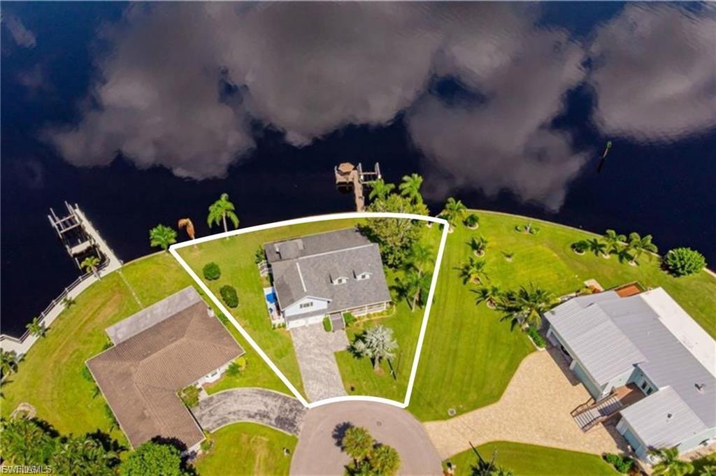 Welcome home to this furnished elevated home only steps from the intracoastal waterway. Experience Naples elegance and lifestyle on the water at a Ft. Myers price point. This home is professionally designed with luxuriously appointed finishes and materials only the discerning can appreciate. Enjoy 155’ of river frontage that sits at a point into the river, giving dramatic sunrises and sunsets in each direction. Recently remodeled inside and out between 2022 and 2026, the exterior is freshly painted, a new cobblestone paver driveway and impact doors and windows. The interior boasts 7 1/2” plank European White Oak flooring throughout the first floor, as well as new upscale molding, cabinetry, countertops, plumbing and more. Upon entering the double paneled front doors, one is greeted with an expansive open plan great room, dining and kitchen; great for entertaining. Each room in the home has an unbelievable view of the river. The kitchen stuns with a large center island in exotic quartzite that emulates the soft waters of the river. A farm sink, SS appliances, unique plumbing fixtures, dazzling cabinet hardware and marble backsplash will not disappoint. The butler’s pantry adds great storage, counter space and a hammered nickel sink. The expansive upstairs owner’s suite shines with a rustic hardwood floor, vaulted ceiling and a private balcony directly overlooking the river. The walk-in closet is custom designed by California Closets. The bathroom offers a high end marble look tile, Kohler soaking tub, large open shower and custom wood double vanity with a shimmering granite top. The soaking tub opens to the suite with custom stained wood shutters to enjoy the fireplace and view to the river. The additional upstairs suite is also as spacious with vaulted ceilings and river view. The bathroom is classically appointed with a chandelier and custom vanity with an ethereal quartzite top and marble vessel sink. The marble subway tiled vanity wall runs to the vaulted ceiling for dramatic effect. Additional features are satin nickel Kohler fixtures and walk in closet. The large private guest room on the first floor whispers an exotic destination with large windows and French doors overlooking the river and preserve beyond. The attached bathroom/pool bath is wrapped in a decadent 24” x 48” agate patterned tile. The vanity is adorned with a stunning hand made ceramic octopus vessel sink. Enjoy your morning coffee on the enclosed screened patio while watching the sunrise and the manatee and dolphin, only feet away. The walk out composite dock offers a 7,500 lb. boat lift and a spacious seating area that seemingly floats in the middle of the river for those magical sunset evenings.