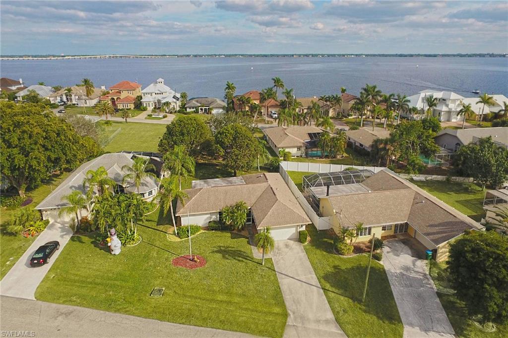 What a great location in the Gold Coast area of Cape Coral on a culdesac. Just one block from the river!  This is the best living you can get on a quiet street, but close to all the shopping and dining.  In an area of upscale Gulf access homes!! The home feels much bigger than the sq ft noted.  It is very open to the HUGE lanai and back yard.  Plenty of room to add a pool.  All Assessments paid!!! The kitchen and bathrooms have been updated and look amazing.  There is carpet in the master and one guest room, all the other floors are tile.  The windows in the kitchen and bathrooms are impact windows.  This home is a must see.  It will not disappoint!!  This house has so many storage areas, and  pulldown stairs to the attic in the garage.