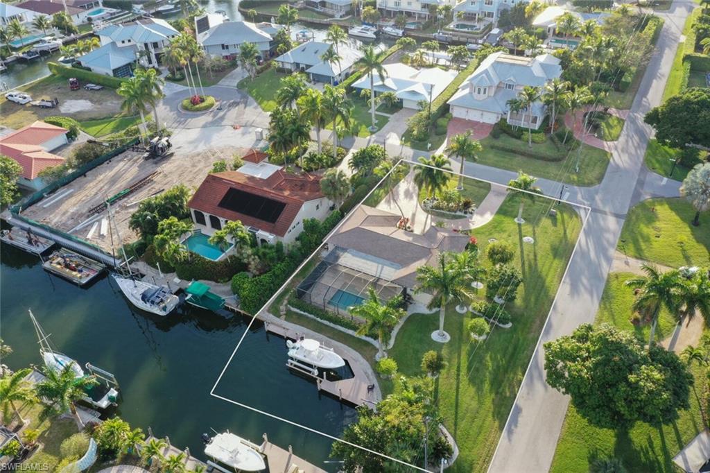 Looking for the perfect location? Purchase this extremely desirable large corner lot home nestled right in a boater’s paradise. This house is a stones throw from Naples Bay, on a deep water canal, and just minutes to Downtown and Fifth Avenue restaurants, shopping and white sandy beaches. You’ll find yourself in the highly sought after community of Royal Harbor as this property offers the benefits and features of a “True” neighborhood and local vibe. 
Featuring 2 bedroom plus den, 2 baths and a 2 car garage, this home provides an opportunity to move in and enjoy! If you are considering building your forever home in a boater’s paradise, look no further as the current owner has done the work for you and will provide fully approved, engineered and permitted plans designed by MHK, a prominent architect firm in the community,  The new home plan features a 4 bedroom, 4 full bath, 2 half baths, 3 car garage, plus loft designed as 4,100 sq. ft under air / 5,600 sq. ft. under roof (new home plans available to purchaser).
Southwest Florida outdoor living begins here with lush landscaping, a spacious covered lanai and relaxing pool.  The waterfront property boasts a 90’ length Seawall, versatile dock and a 12,000 lb. boat lift. Schedule a viewing of this home immediately off of Naples Bay with easy gulf access. Don’t wait to start living the Florida waterfront lifestyle, this one will not last long!