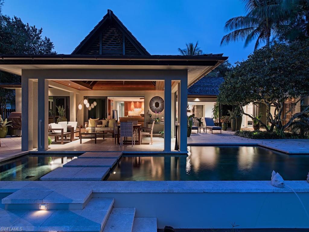 H.11340 - A private realm of timelessness and tranquility, this Aqualane Shores home masterfully blends classic Balinese architecture with a clean lined contemporary interior to create a one-of-a-kind home that is dripping with style.  Cedar Shake roof, copper architectural gutters and lush tropical landscaping frame the front elevation.  The interior finish is defined by sleek clean lines and a minimalist approach with strong accent materials.  Features include large, slate tile flooring throughout, wood beam and tongue & groove ceiling detail, gorgeous custom lighting chandeliers, custom cabinetry and wood work and much more.  Kitchen includes granite countertops, ample counterspace, beautiful cabinetry, large island and double wall ovens. The open lanai is a resort like escape with tiki bar, covered gazebo with intricate wood beamed tongue and groove ceiling detail, custom pool/spa with floating stone steps that lead down to the large wood dock with boat slip and two boat lifts. This is a home that its sum is greater than its parts and must be seen to be truly appreciated.