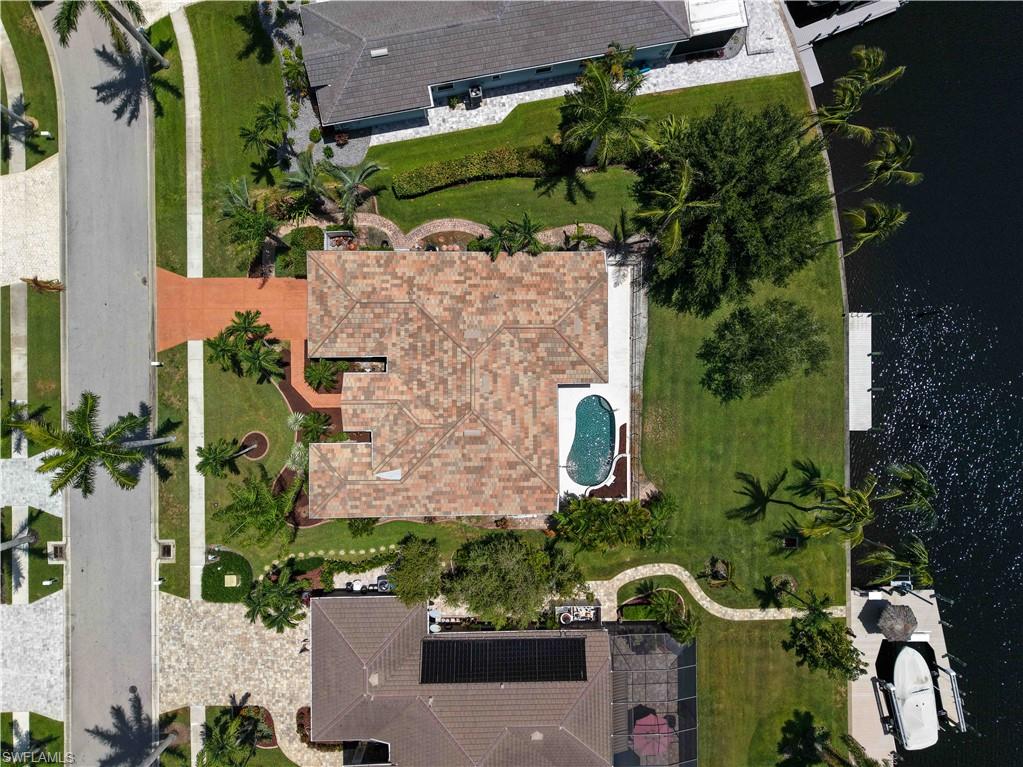 Welcome to the first-time offering of this exceptional waterfront home, perfectly positioned on a direct Gulf Access canal with **121 feet of seawall** and breathtaking **wide intersecting canal views** that create the perfect backdrop for unforgettable Southwest Florida sunsets. Designed with the boating enthusiast in mind, the expansive waterfront easily accommodates larger vessels, and **open water is just minutes away**, making every day an invitation to explore the Gulf.

Lovingly maintained by its original owner, this custom residence showcases timeless architecture, quality craftsmanship, and thoughtful design throughout. Spacious living and family rooms are perfectly positioned to capture the tranquil water views, creating an inviting setting for both everyday living and entertaining.

The kitchen features rich cherry-glazed cabinetry, recessed lighting, stainless steel appliances, a built-in wall oven, and a sleek cooktop. The private primary suite has been enhanced with updated flooring and offers a peaceful sitting area, while the luxurious primary bath offers recently updated cabinetry and countertops, dual vanities, a tiled walk-through shower, and a relaxing sunken soaking tub.

Additional highlights include a **2023 tile roof**, **2023 5-ton air conditioning system**, central vacuum, elegant trim work, and numerous custom architectural details that add character and charm throughout the home.

Whether you're searching for an exceptional boating property or a peaceful waterfront retreat, this rare Cape Harbour opportunity offers an unbeatable combination of location, quality, and spectacular views.  Owner has an affordable transferable Flood Policy that offers additional peace of mind.
