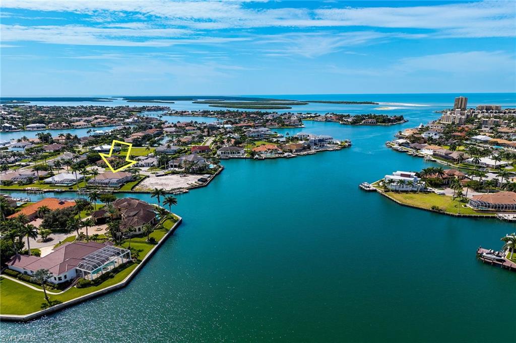 Located in the exclusive Marco Island Estates. This magnificent 3-bedroom plus den, 3.5-bath, with oversized garage, circular drive lined with Royal Palms and exquisite landscaping. Situated on nearly half an acre with 147 feet of prime waterfront, this exceptional Divco custom designed residence offers over 3,800 square feet under air and more than 4,000 total square feet of exceptional living space. The spacious home features soaring volume ceilings enhanced by exquisite custom moldings and features throughout, creating an atmosphere of elegance. The gourmet kitchen serves as the heart of the home, highlighting custom cabinetry, a generous center island with breakfast bar, and a complete suite of stainless-steel premium appliances and a large pantry. The luxurious master suite features a spacious bedroom with private sitting area, two large, oversized closets and master bathroom with dual vanities, soaking tub, and separate shower. Home has separate formal dining room for entertainment and a breakfast area with bay view. Living room and family room have fantastic water views and open to an impressive lanai with even better water views, multiple seating areas and resort style pool and hot tub. Covered lanai extends the entire length of the home, enjoy year-round sunshine, spectacular sunsets, continual parade of boats, and many playful dolphins to watch. Boating and fishing enthusiasts will appreciate the private marina featuring three boat lifts, including two 16,000-pound lifts for larger boats and one 8,000-pound lift for smaller boats or jet skis. Great fishing off the docks or the deep-water canal provides quick access to the Gulf of America, placing world-class fishing waters and the 10,000 Islands just minutes away. Additional premium amenities include a central vacuum system, new roof in 2018, 30 KW liquid cooled generator with underground 500-gallon propane storage tank. Mature, well-maintained landscaping, including banana trees thrive throughout the estate. Marco Island's finest dining, shopping, and pristine beaches within minutes of this exceptional waterfront estate home.