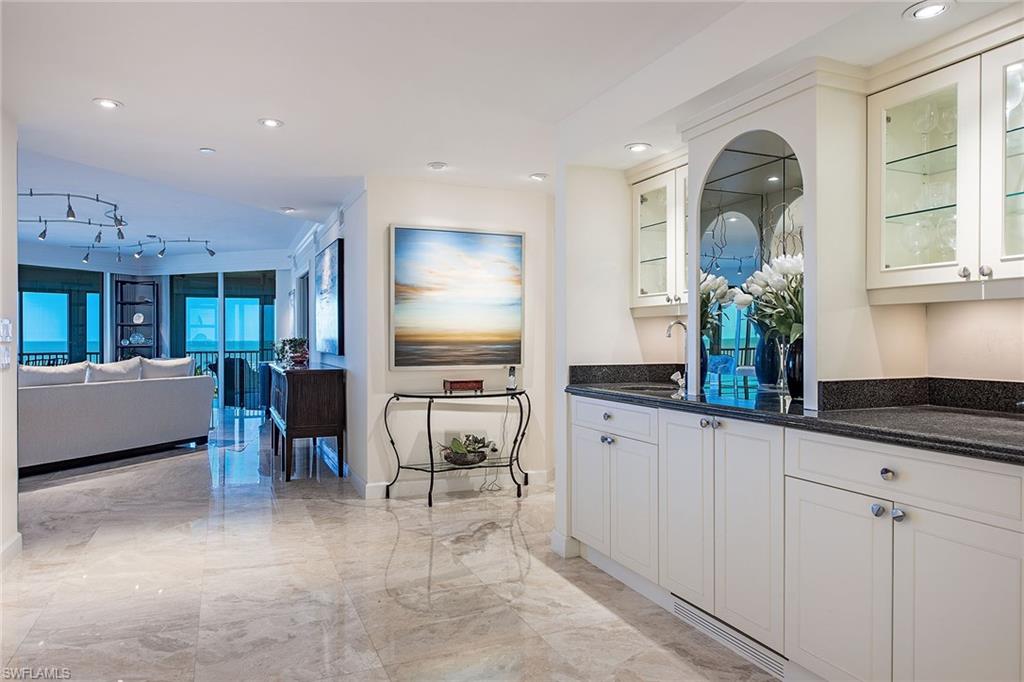 Rarely available, this stunning 04 end-unit residence offers breathtaking, unobstructed views of the Gulf and pristine beach. Directly on the beachfront, this 2,626-square-foot home provides abundant natural light through walls of glass and meticulously maintained to perfection. Boasting three spacious bedrooms plus a versatile den/media room, three full baths and a half bath, this residence features luxurious marble flooring throughout. Enjoy the expansive, wrap-around lanai, ideal for relaxing or entertaining while taking in the panoramic vistas. Additional highlights include two deeded parking spaces, extra air-conditioned storage, and exclusive access to Bay Colony's prestigious beach and tennis clubs. As a resident, you also enjoy membership privileges at Pelican Bay, offering two more beachfront dining options.