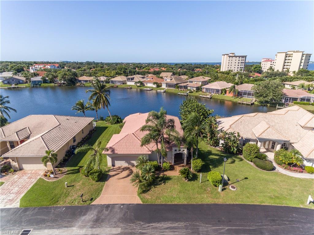 This custom home is located on a quiet cul-de-sac in Waters Edge and includes many fine upgrades. Keep your boat right in your back yard at the boat dock which was installed in 2011. This is a freshwater lake and gulf access is via boat ramp at the community's private marina. This 3/2/2 plus den features soaring ceilings, surround sound throughout, crown molding, new tile in main living areas and new baseboards throughout, indoor laundry room with extra cabinets and utility sink, security system and plantation window treatments. The kitchen features new wood cabinets with self-closing drawers, spectacular island, granite countertops and stainless steel appliances. Spacious owners retreat with walk-in closets, dual sinks and separate tub and walk-in shower. Community amenities include pools, tennis courts, walking/jogging path, low HOA fees, and one of longest fishing piers in SW Florida. New A/C and garage door in 2018.