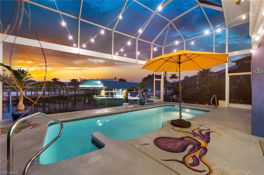 Margaritas, sunsets, and island time await at this waterfront retreat in the heart of St. James City. Designed for those who dream of a laid-back tropical lifestyle, this elevated coastal home combines boating, entertaining, and carefree island living into one unforgettable package. The main living level features 2 bedrooms, 2 baths, and an open great room floor plan that flows seamlessly to the screened waterfront lanai. The beautifully remodeled primary suite offers a walk-in closet and spa-inspired bath featuring dual vanities, a custom walk-in shower with multiple shower heads, and a luxurious rain shower. The updated kitchen shines with quartz countertops, subway tile backsplash, stainless steel appliances, upgraded hardware, and plenty of room for gathering with family and friends after a day on the water. Downstairs, guests will love the private bungalow-style suite complete with its own entrance, new mini-split system, updated cabinetry, vanity, lighting, and en-suite bath with walk-in shower. The lower level also offers an oversized 2-car garage with extended storage space for fishing gear, kayaks, golf cart, and all your island toys and workshop.  Step outside to the screened pool area where colorful ocean-themed murals, tropical breezes, a private outdoor shower, and comfortable gathering spaces create a true vacation-at-home atmosphere. Outside, the property feels like a private botanical garden with mature palms, native landscaping, fruit trees, granite-lined flower beds, tiki lighting, solar accent lighting, irrigation system, and multiple outdoor entertaining spaces. Boaters will appreciate the covered 8K  boat lift with newer canopy, fish-cleaning station, dock lighting, snook light, updated dock electrical, rewrapped pilings, and quick access to Pine Island Sound, world-class fishing, waterfront restaurants, secluded beaches, and the Gulf waters beyond. Extensively improved for peace of mind, major updates include a stone-coated metal roof rated for 200 mph winds (2023), hurricane impact windows and pocket slider (2026), new picture-window pool cage (2024), resurfaced pool with new tile (2023), raised HVAC equipment (2025), A/C system with warranty through 2028, elevated water heater, slab-jacked driveway and pool deck with lifetime warranty, new gutters, soffits and fascia, updated electrical, new insulation, fresh interior and exterior paint, remodeled primary bath, and numerous additional upgrades throughout. Whether you're boating to lunch, relaxing poolside under the tiki lights, or enjoying a sunset cocktail from the screened lanai, this island escape delivers the authentic Pine Island lifestyle you've been searching for.