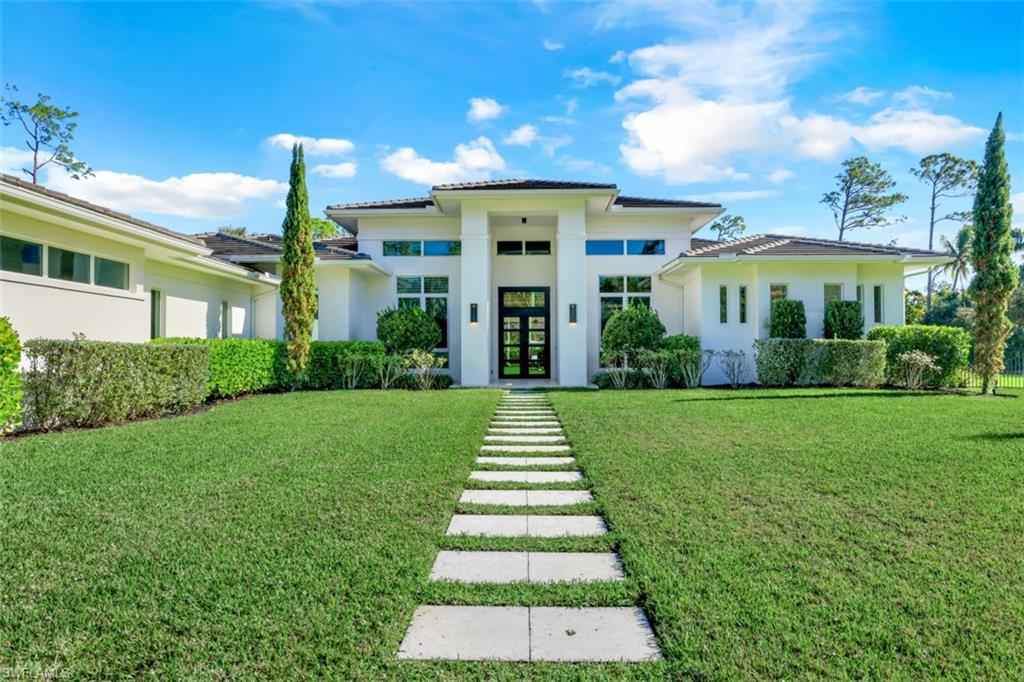 H4419 -Welcome home to this move in ready, contemporary stunner on in town acreage in prestigious Pine Ridge. This sophisticated home sits on 1.65 manicured acres & features a single story, great room floor plan. With nearly 7500 square feet living space under roof, this FIVE bedroom + den, five & 1/2 bathroom, 3 car garage home has room for everyone.  An entertainer’s delight, this home centers around the gourmet kitchen w/ a large contrasting island, Thermador appliances, quartz counters, integrated walk-in pantry, gas cooktop, double wall ovens and custom cabinetry. The adjacent butler’s pantry features a Subzero wine refrigerator/beverage center, additional cabinetry, second dishwasher & a stunning glass wine wall. The primary bedroom features glass sliders to the lanai, a separate “glam” / hobby room, two custom closets & a spa-like bathroom. The expansive outdoor area offers an abundance of space for dining & relaxing with an outdoor kitchen, linear gas fireplace, electric roll down screens, gas fire pit & a large salt water pool & spa, complete with fire bowls. The beautiful backyard is fully fenced. Upgrades include impact windows & doors & Control 4 Smart-Home Technology.