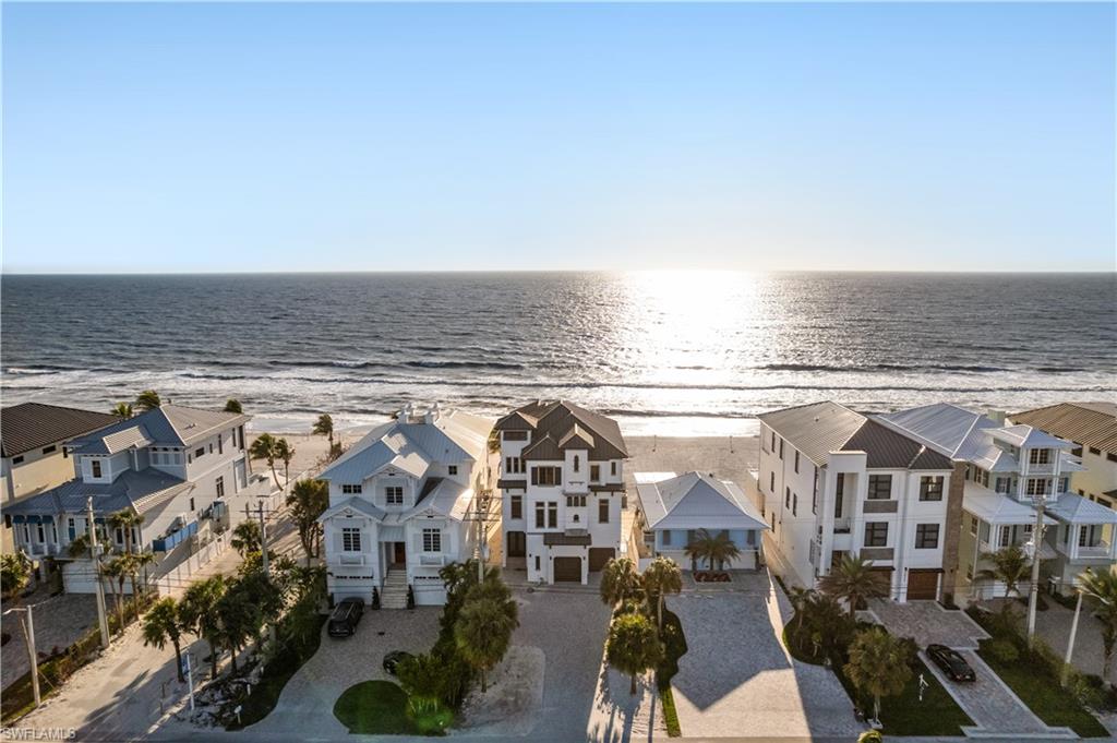 Stunning & newer-built beachfront home with breathtaking views of the Gulf, ideally situated on the highly coveted Bonita Beach. With unobstructed views of the turquoise waters and pristine white sands, this home is a true coastal gem. Built like a fortress, this home features all concrete-block construction and brand-new hurricane impact windows and sliders. Perfect for entertaining, the spacious open floor plan includes 4 bedrooms, 5.5 bathrooms, an expansive upstairs bonus room, and a versatile ground-floor flex space. Step outside to a private backyard oasis, complete with a RARE elevated pool and spa, a summer kitchen, and panoramic Gulf views. Inside, you'll find luxurious finishes throughout, including custom wood-paneled coffered ceilings and a seamless blend of hardwood and travertine tile flooring. The chef’s kitchen boasts granite countertops, an oversized island, light colored custom cabinetry, an eat-in area, and a breakfast bar perfect for casual dining. Adjacent to the kitchen is a custom bar area with a built-in wine cooler, wet bar, and additional bar seating—ideal for entertaining guests. The expansive primary suite offers a serene retreat with sweeping Gulf views, a private balcony to enjoy spectacular sunsets, and a spa-like bathroom with dual vanities, a frameless glass shower, and a separate soaking tub. The upper-floor bonus room is a versatile space, complete with an ensuite bathroom, wet bar with beverage cooler, and an open-air balcony—perfect for a media room, office, or additional living area. Additional features of this home include a private elevator and a smart lighting system. Close to several fantastic restaurants and only a 10-minute drive to Mercato and the Promenade, with Waterside Shops, Coconut Point, Naples 5th Ave, and the International Airport nearby. Live the ultimate coastal lifestyle with sweeping views of the Gulf—this is luxury living at its finest!