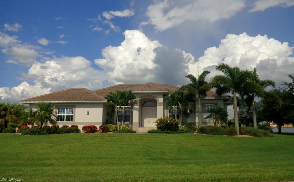 Fabulous custom great room home in the deed restricted community of Burnt Store Lakes is nestled on two lots situated at the lakes edge! Located at the end of a quiet cul-de-sac, this quality 3 bedroom + den home was built by one of the area’s best custom home builders in 2007; featuring an open floor plan with dramatic tray ceilings & a side loading oversized garage. Diamond set tile runs through the main living area & is complimented by a neutral color scheme all of which frames the scenic pool & lake view. The kitchen boasts cherry toned, raised panel cabinetry with crown tops & granite counters that provide for bar seating. The kitchen is extended into the nook with a companion hutch. The den off the great room can be closed off with glass French doors & features rich wood toned flooring & plantation shutters. The master suite features a spacious bedroom with 10' tray ceilings, his/her walk in closet, a bath with walk-in Roman shower, soaking tub & dual sinks. Outdoor living is a delight from this eastern facing lanai. You can lounge by the heated pool, as you gaze off at the lake which is flanked by Royal Palms. Full storm protection completes this fine home.