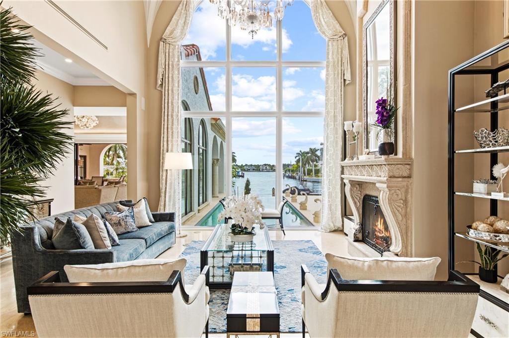 Masterful updates welcome you to all Naples has to offer in this exquisite property with Bay view with more than 100 feet of deepwater frontage on an estate-sized lot. From the foyer you and your guests will begin to see all that is special about this home.  Each corner of the home is special including, but not limited to, the custom kitchen with Wolfe Appliances, Custom Backsplash, custom paint treatment overhead in both the living and family rooms, stunning custom lighting and fixtures. The exterior has panoramic views from the lanai which boasts an outdoor kitchen and bar, a 20,000 pound boat lift, separate jet ski lift, invisible edge pool and spa with iMist™ Monitoring to keep pests far from you! With four gracious bedrooms, a gracious home office/den/additional guest room, the floor to ceiling views of the Bay are magnificent and are enjoyed from the Owners suite, the guest suite, living and family rooms.  The formal Dining room is large enough for your most impressive events and the breakfast room with built-ins make managing this property a dream. All this 5 minutes from Downtown.
