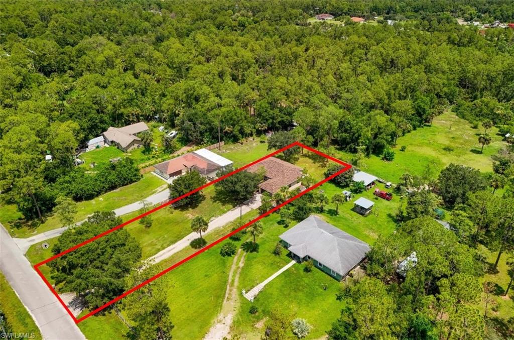 MOVE-IN READY HOME WITH A NEW ROOF ON 1.14 ACRES! Welcome home! This amazing 3-bedroom, 2-bath retreat sits on 1.14 acres with a fenced backyard, offering the space, privacy, and freedom families are searching for in Golden Gate Estates. Room to roam for kids, plus plenty of space for vehicles, or that future workshop you've been dreaming of. The home is set back from the road on a LONG PAVED DRIVEWAY and 2 CAR-GARAGE for extra privacy and convenience. Recent updates give you real peace of mind from day one: a BRAND-NEW ROOF, a NEW DRAINFIELD, FRESH INTERIOR PAINT, UPGRADED LANDSCAPING, and a NEW WATER SOFTENER SYSTEM. Step inside to a SPLIT-BEDROOM FLOOR PLAN, TILE FLOORING THROUGHOUT, HIGH CEILINGS, and beautiful natural light pouring through oversized arched front windows. A formal living room and separate formal dining room set the stage for holiday gatherings, while the spacious family room flows right into the kitchen, perfect for keeping everyone together, whether it's a quiet weeknight dinner or a house full of guests. The kitchen itself is made for making memories, featuring STAINLESS STEEL APPLIANCES, a pantry, and a cozy breakfast nook overlooking the family room. Retreat to the primary suite for a true escape, complete with a TRAY CEILING, sliding glass doors to the lanai, dual WALK-IN CLOSETS, and a spa-like bath with separate vanities, a SOAKING TUB, and a glass-enclosed walk-in shower. Then head outside to the LARGE SCREENED LANAI overlooking your FENCED BACKYARD, an ideal spot for morning coffee, evening relaxation, or weekend get-togethers with family and friends. Tucked near the end of a quiet dead-end street with mature trees and lush landscaping, this home offers true freedom with NO HOA fees or restrictions, all just minutes from shops, supermarkets, and top-rated Naples schools. Perfect for growing families, those craving more space and privacy, or anyone looking for a smart investment in a rapidly growing area. Schedule your private showing today and come experience the freedom for yourself! THIS PROPERTY QUALIFIES FOR A 1% LENDER INCENTIVE IF USING PREFERRED LENDER, INQUIRE FOR MORE DETAILS* One or more photo(s) has been virtually staged, AI generated, or rendered.