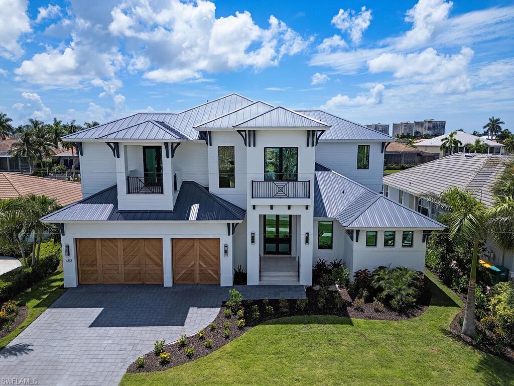 Discover coastal luxury in this brand new direct access waterfront home in the Marco Island Tigertail Beach area, with coveted southern rear exposure, wide water views, a short 10-minute boat ride to the Gulf. The front exterior showcases custom 9' herringbone patterned cedar garage doors, accented by sconces & soffit lighting, complementing the lush zoysia grass lawn & tropical landscape, creating a warm inviting entrance. Step through grand glass & metal double doors into a sophisticated haven, where 13.5' tray ceilings & expansive 10' sliders create a light-filled atmosphere & frame the breathtaking wide waterway views. Wide-plank white oak flooring, custom ceiling accents, & designer lighting & plumbing create an ambiance of refined luxury. At the heart of the home, the kitchen showcases custom floor-to-ceiling white oak cabinetry & integrated appliances. The marble countertops & full-slab backsplash create a seamless look, while the substantial marble island stands as a striking focal point. With professional-grade GE Professional Monogram appliances, a 47" chef’s sink, & expansive walk-in butler’s pantry, ideal for culinary enthusiasts. Be the first to experience the cutting edge of design & performance with Dekton, a stone material from Spain that boasts non-skid properties, a cool-to-the-touch feel, & resistance to UV rays, stains, & scratches, setting a new benchmark for luxury & durability. The pool area showcases Dekton tile surround & integrated bullnose, blending durability with elegance. A sparkling oversized pool with sun shelf & waterfall spa is surrounded by inviting lounge areas, a grill area, & a wet bar. Electric screens & shutters enhance comfort & privacy, making this outdoor oasis perfect for relaxation & entertaining. The primary bedroom features 10’ sliders to the outdoor deck & luxurious spa. 2 large walk-in closets with custom systems provide ample storage. The luxurious primary bathroom is adorned with floor-to-ceiling Dekton tile, creating a serene & sophisticated ambiance. A breathtaking zero-entry wet room featuring double-entry frameless shower doors, an oversized soaking tub, & dual shower heads offer a spa-inspired experience. Extra thick custom Dekton counters with integrated sinks & linear drains complement the custom white oak floating vanities, adding a touch of glamour & refinement. Upstairs, an entertainment loft with a wet bar & sliders opens to a covered terrace, creating a seamless indoor-outdoor experience. This area can serve as a media room, game room, or lounge area, ideal for entertaining & relaxation. All 3 en-suite guest rooms feature private balconies or terraces & comfortably accommodate king-size beds or be transformed into stylish bunk rooms, while walk-in closets with custom systems ensure ample storage. Elevator-ready across 3 levels, this coastal masterpiece features a newer seawall. The builder offers optional designer furnishings & finishing packages tailored to your specific desires.