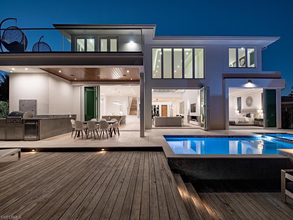 This is an EPIC new waterfront smart home. As you approach you are greeted by the contemporary Mandalay 3 car garage and custom entry water feature. Soaring high 21’ ceilings and Folding Euro-Wall of Windows. The open floor plan features a stunning, back-lite honey onyx wine tasting bar with floor to ceiling glass wine room that will have your guest swooning over the luxury and class it provides. High end finishes throughout include wide plank French oak flooring, quartzite, marble and glass countertops, custom cabinets, 2 dishwashers, Modernist appliances which are amazing! Cameras in the fridge! Brazilian Walnut finishes, linear slot AC diffusers & whole house multi-room audio system w/ 5 zones, 18 build in speakers. Top of the line security including panic room. Master bath is Natural Limestone on floors and shower! Outdoor area features a salt-chlorine pool with hot tub, firepit Brazilian Teak deck w/ full outdoor kitchen with all the best a canal front home can offer. Upstairs living room area. Also has a bar w/ice maker, refrigerator & sink. All bedrooms have bathrooms.  New concrete seawall & direct Gulf Access via Gordon's Pass. Enjoy the dolphins and manatees swimming by.